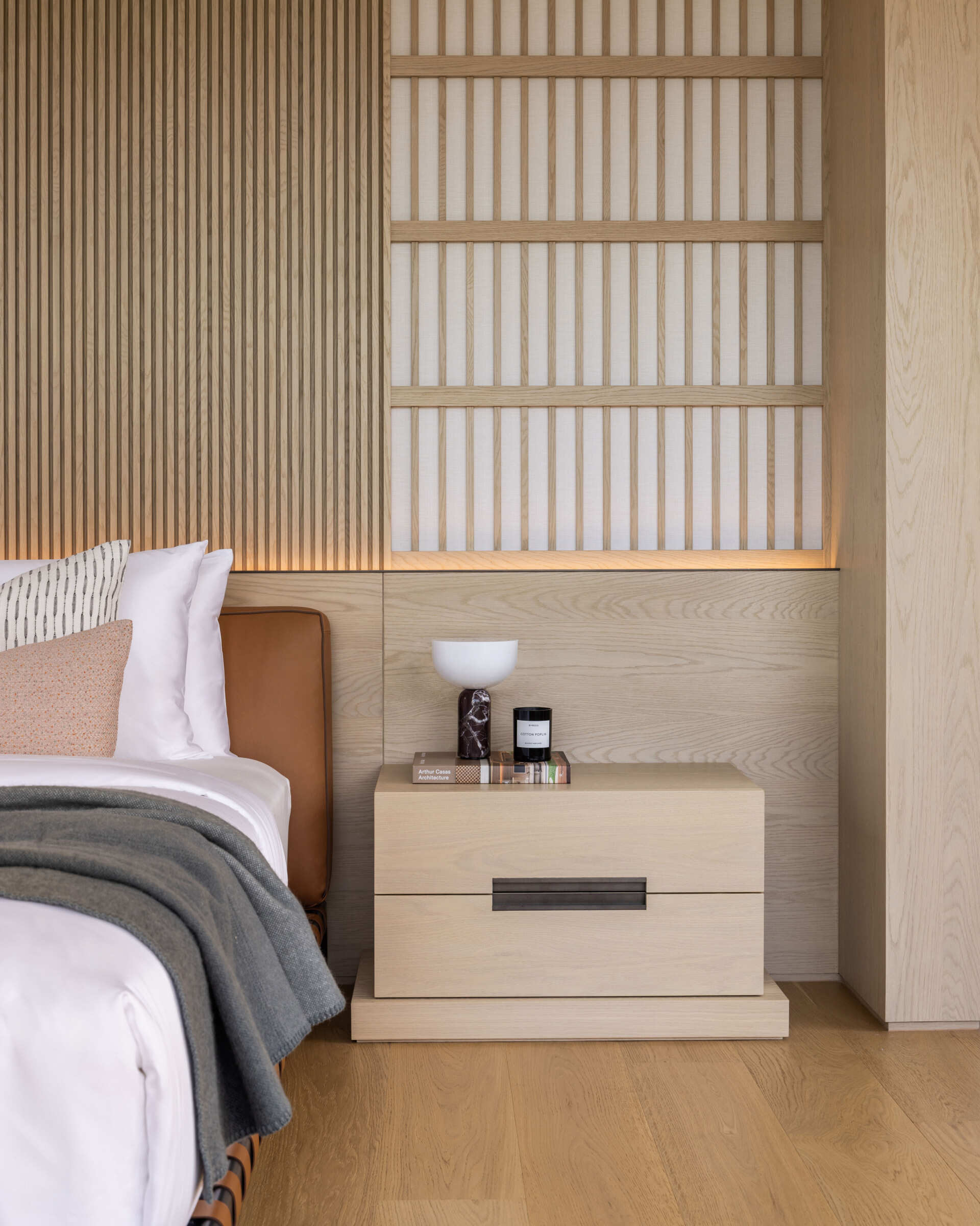 A modern bedroom with screens behind the bed, as well as around the windows.