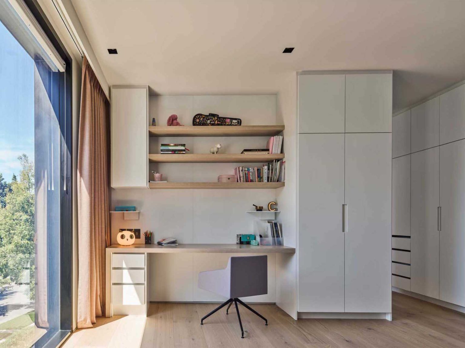 Two bedrooms in Nanton House feature built-in desks, creating dedicated study areas within the warm, contemporary interiors of this multi-generational Vancouver home.