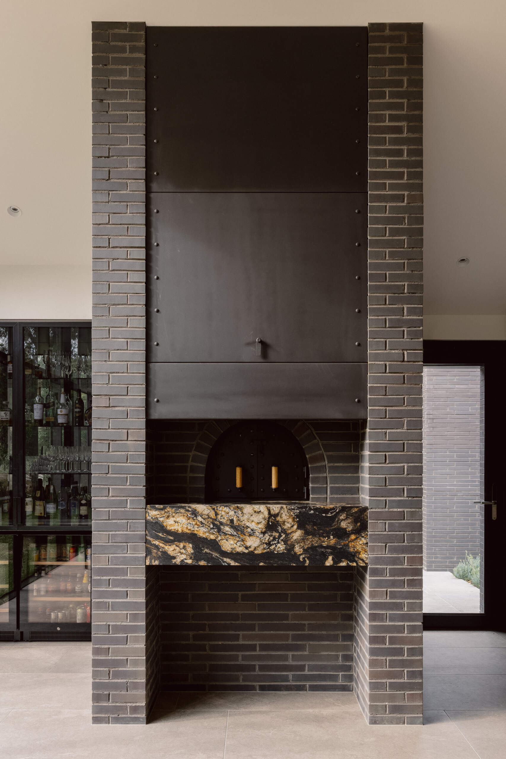 Explore the dining room at Yarra Valley House, where a large timber table, dark brick pizza oven and floor-to-ceiling windows overlook the lush Victorian landscape.