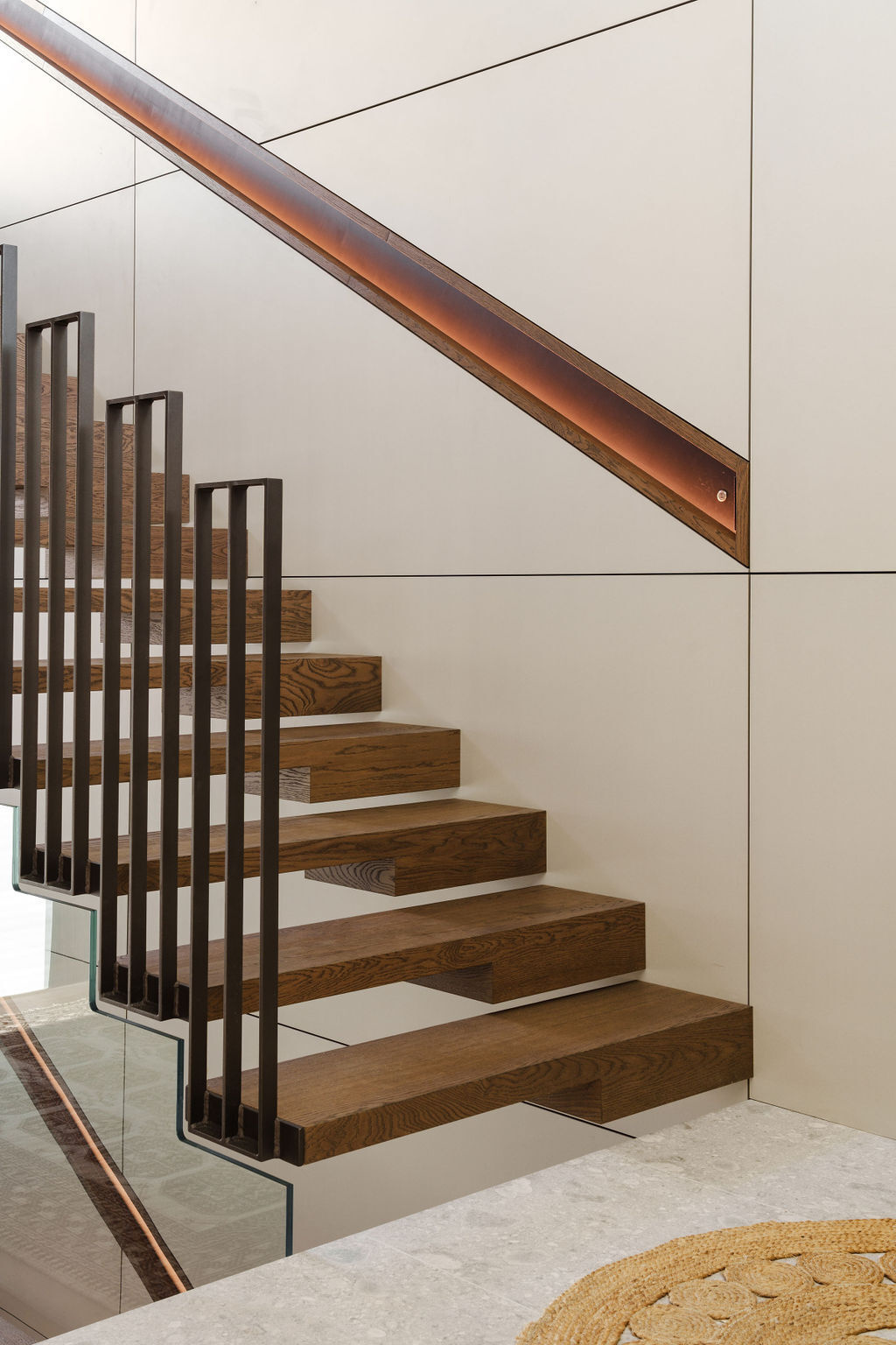 Mezzanine House features two distinctive staircases, combining floating timber treads, black metal, glass balustrades and natural light within the contemporary Perth home.
