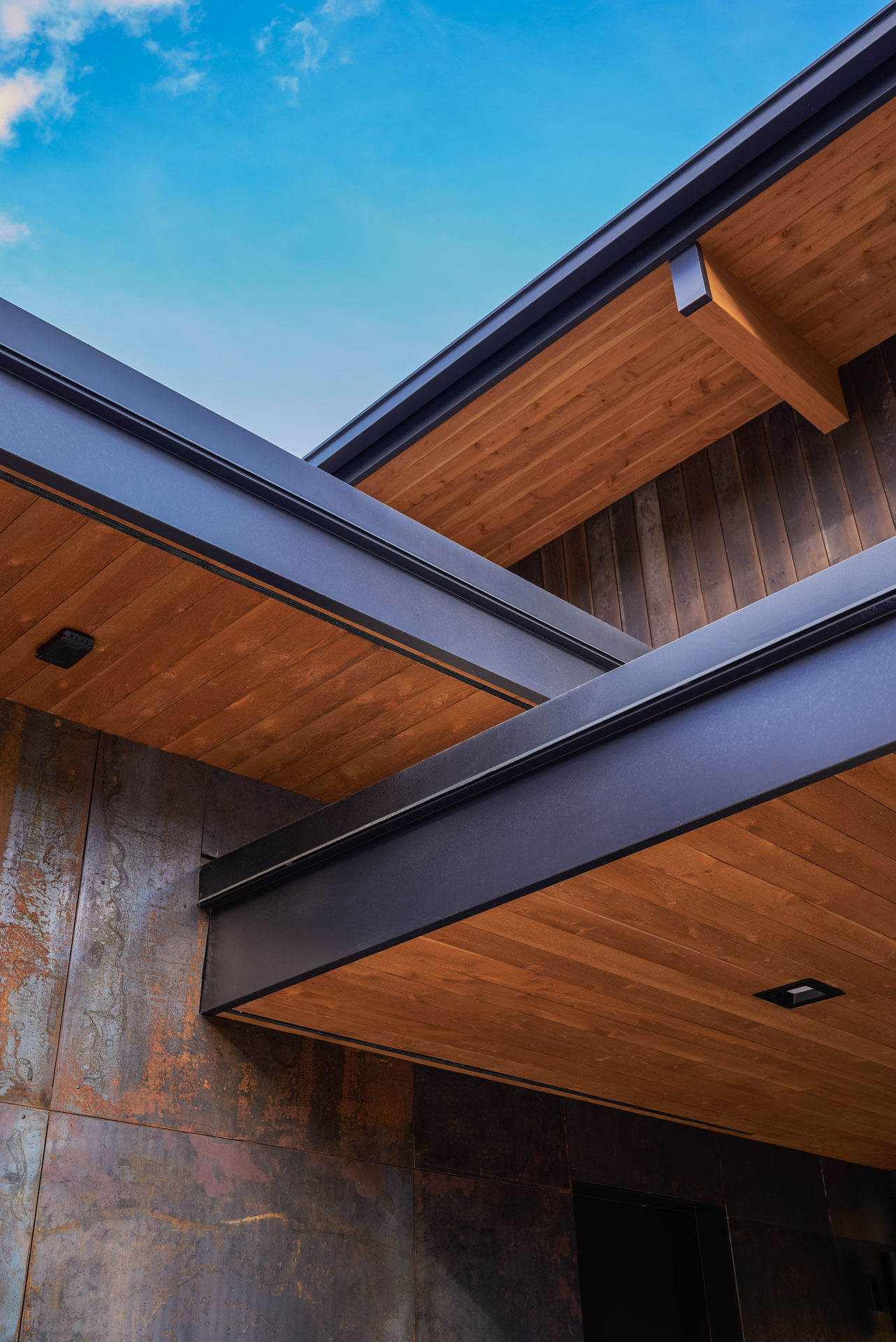 Charred wood siding, raw steel, and warm timber details create a timeless material palette that will naturally weather and develop character over time.