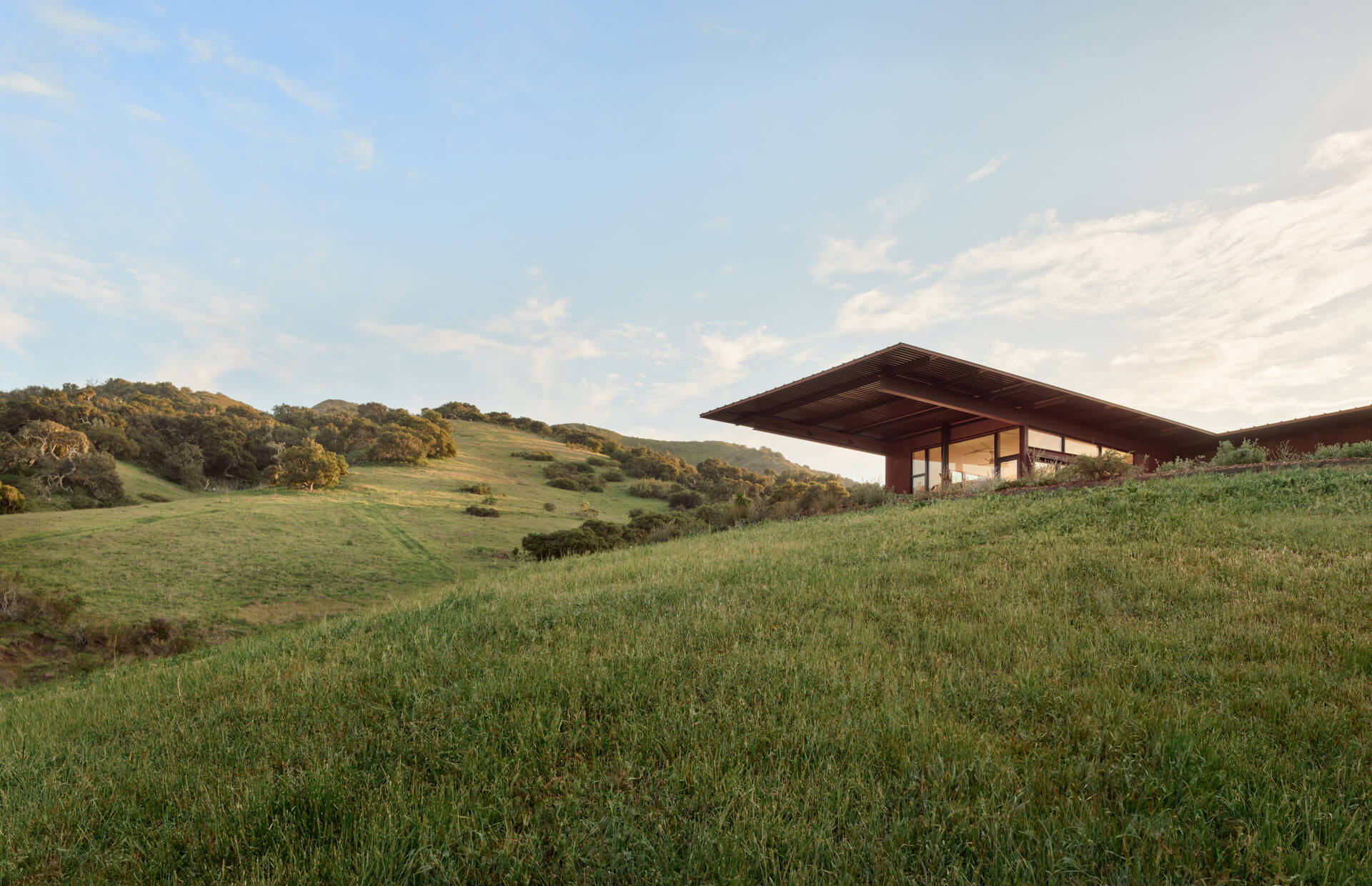 Explore the compact T-shaped plan of Vineyard Residence by Clayton Korte, with private bedroom suites surrounding a central kitchen and living area and outdoor spaces extending at both ends.