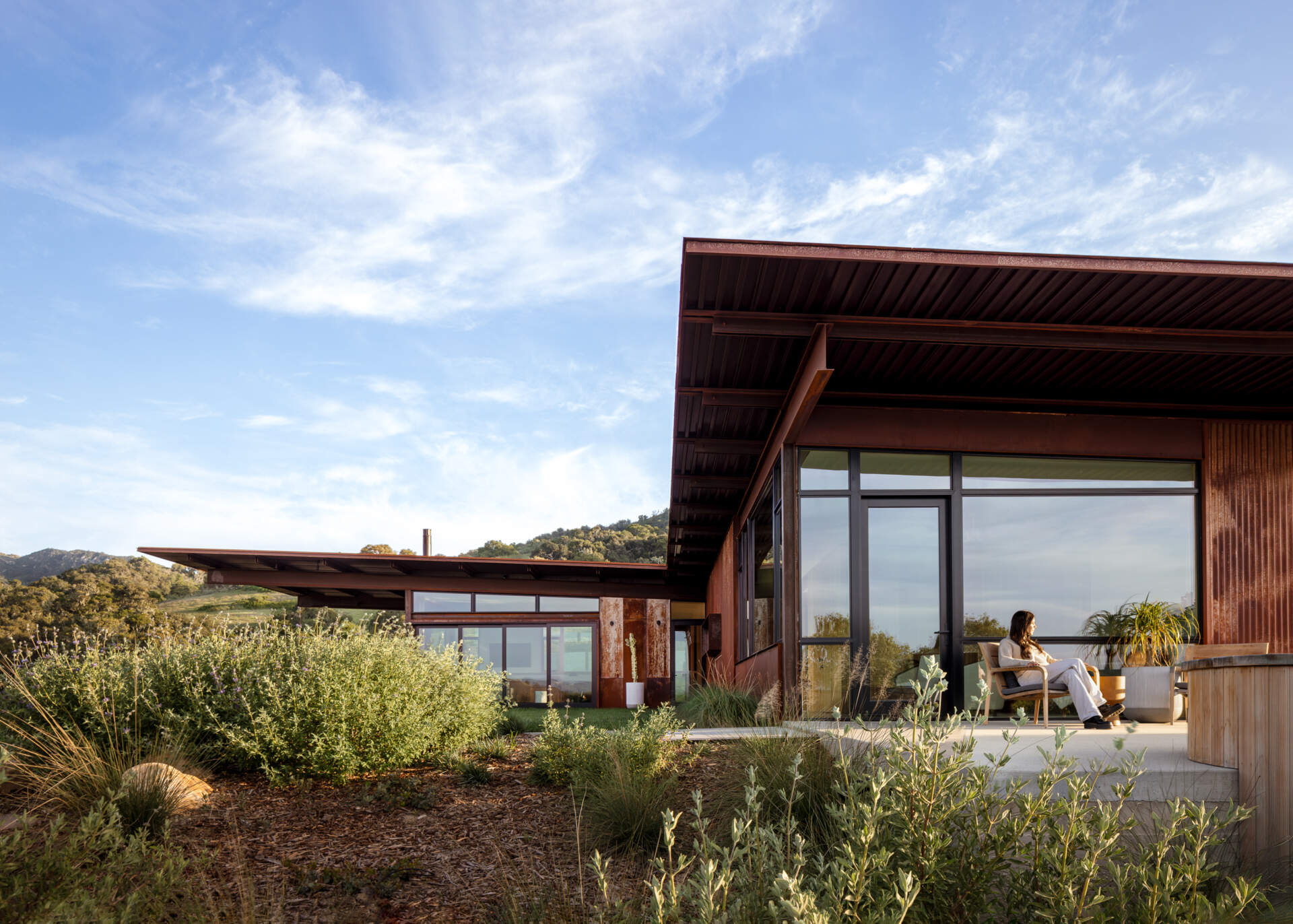 Explore the compact T-shaped plan of Vineyard Residence by Clayton Korte, with private bedroom suites surrounding a central kitchen and living area and outdoor spaces extending at both ends.