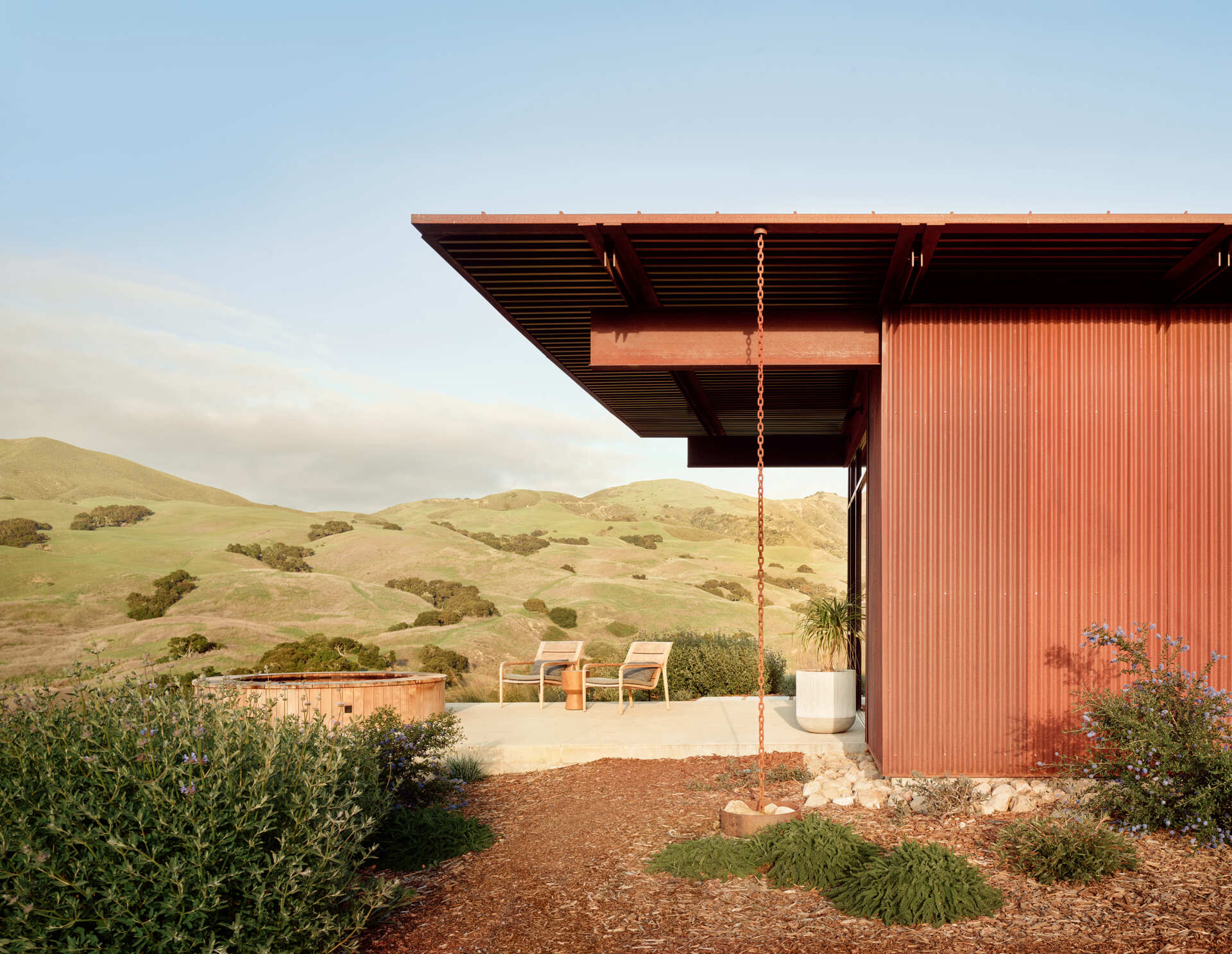 Explore the compact T-shaped plan of Vineyard Residence by Clayton Korte, with private bedroom suites surrounding a central kitchen and living area and outdoor spaces extending at both ends.