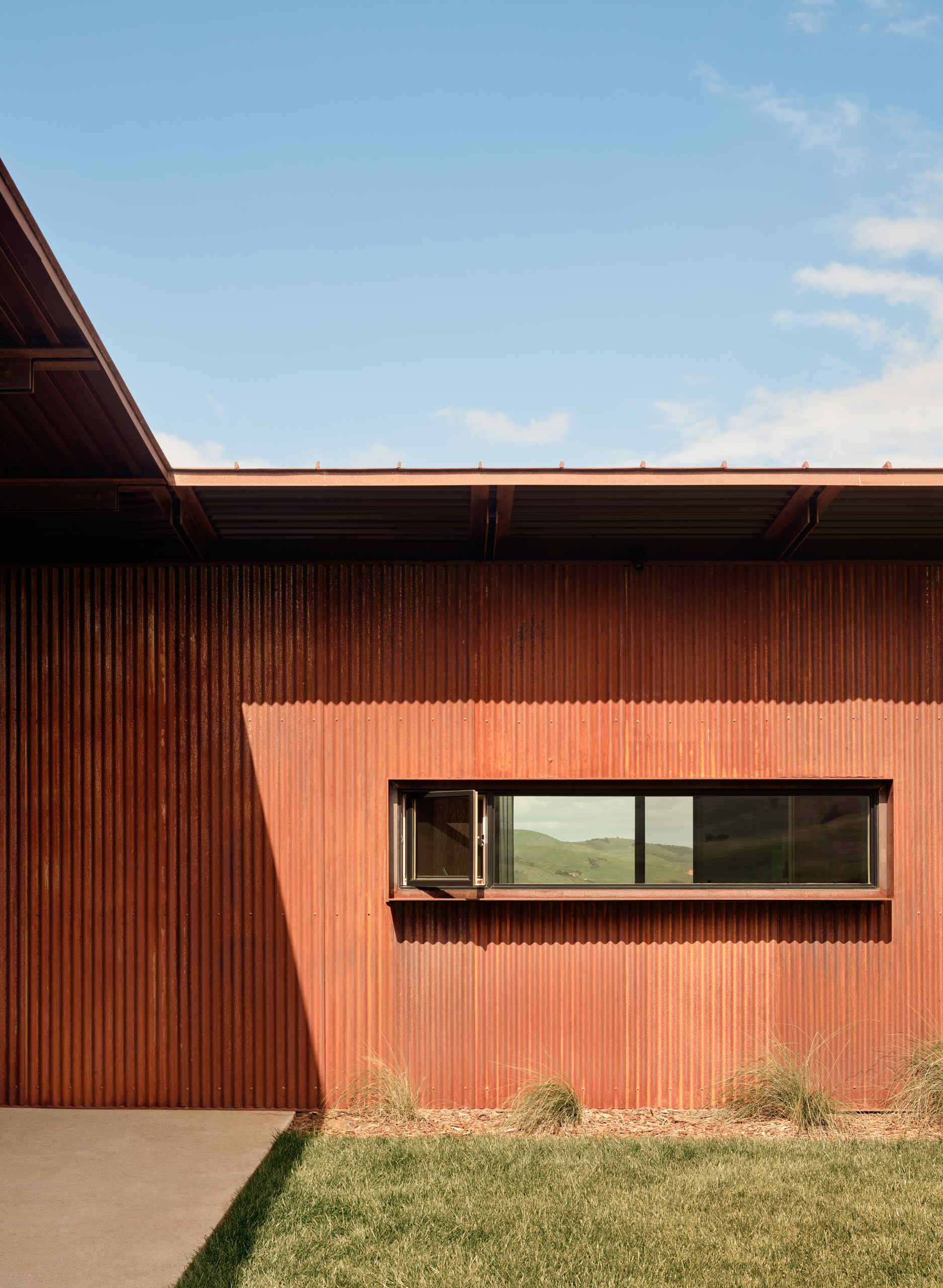 Weathering steel, stucco and a rainscreen give this California vineyard residence a warm, durable exterior inspired by the agricultural character of the surrounding area.