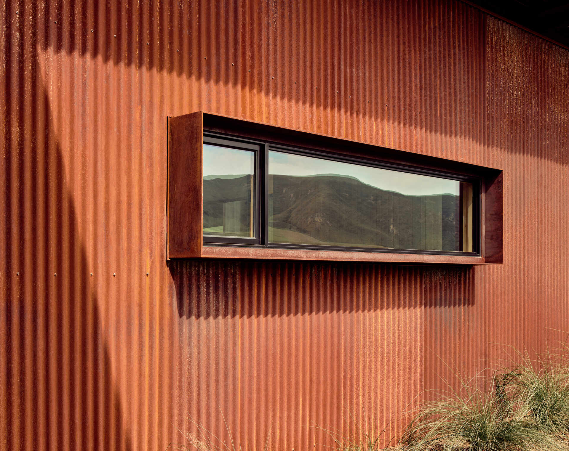 Weathering steel, stucco and a rainscreen give this California vineyard residence a warm, durable exterior inspired by the agricultural character of the surrounding area.