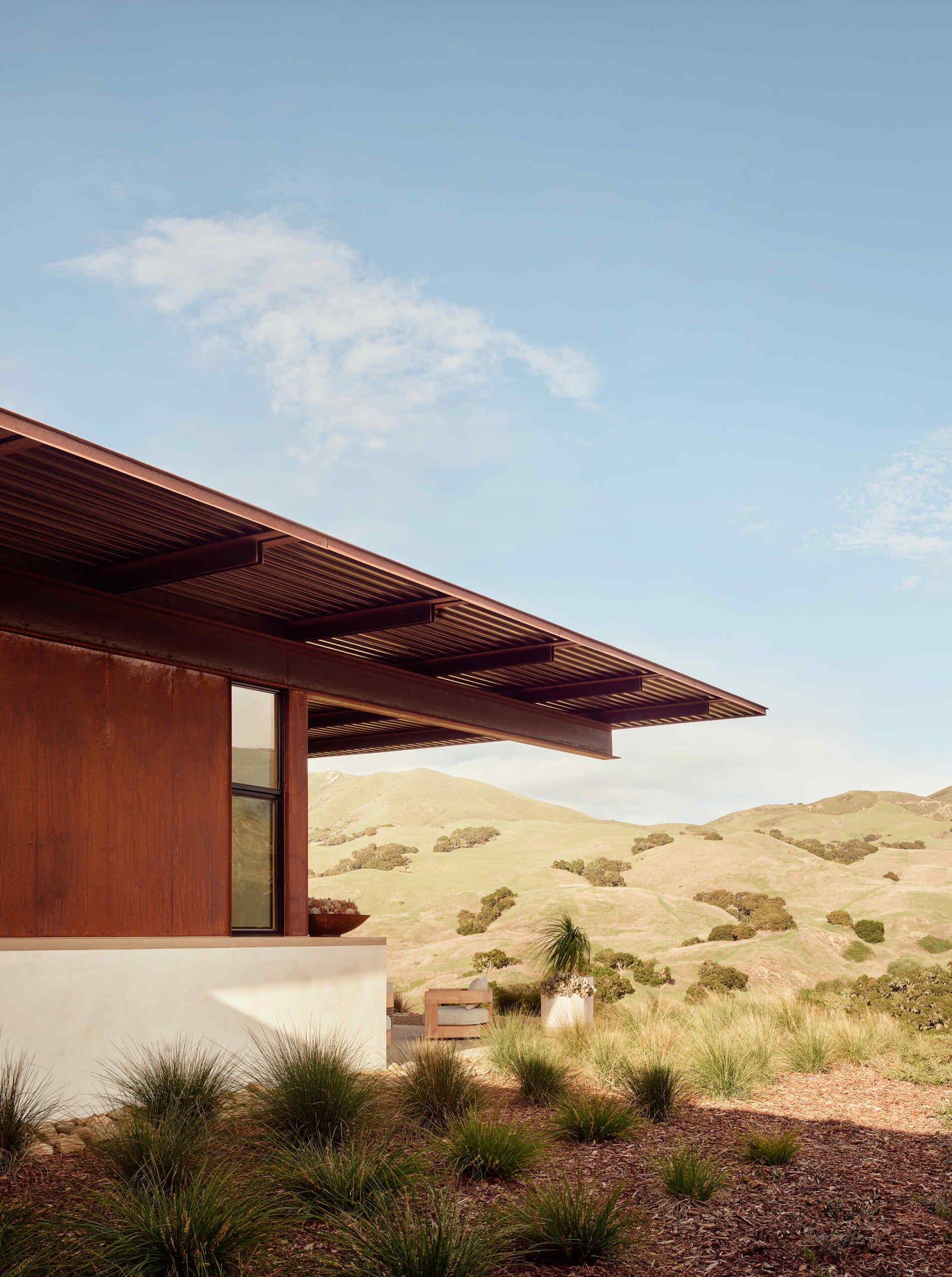 Weathering steel, stucco and a rainscreen give this California vineyard residence a warm, durable exterior inspired by the agricultural character of the surrounding area.