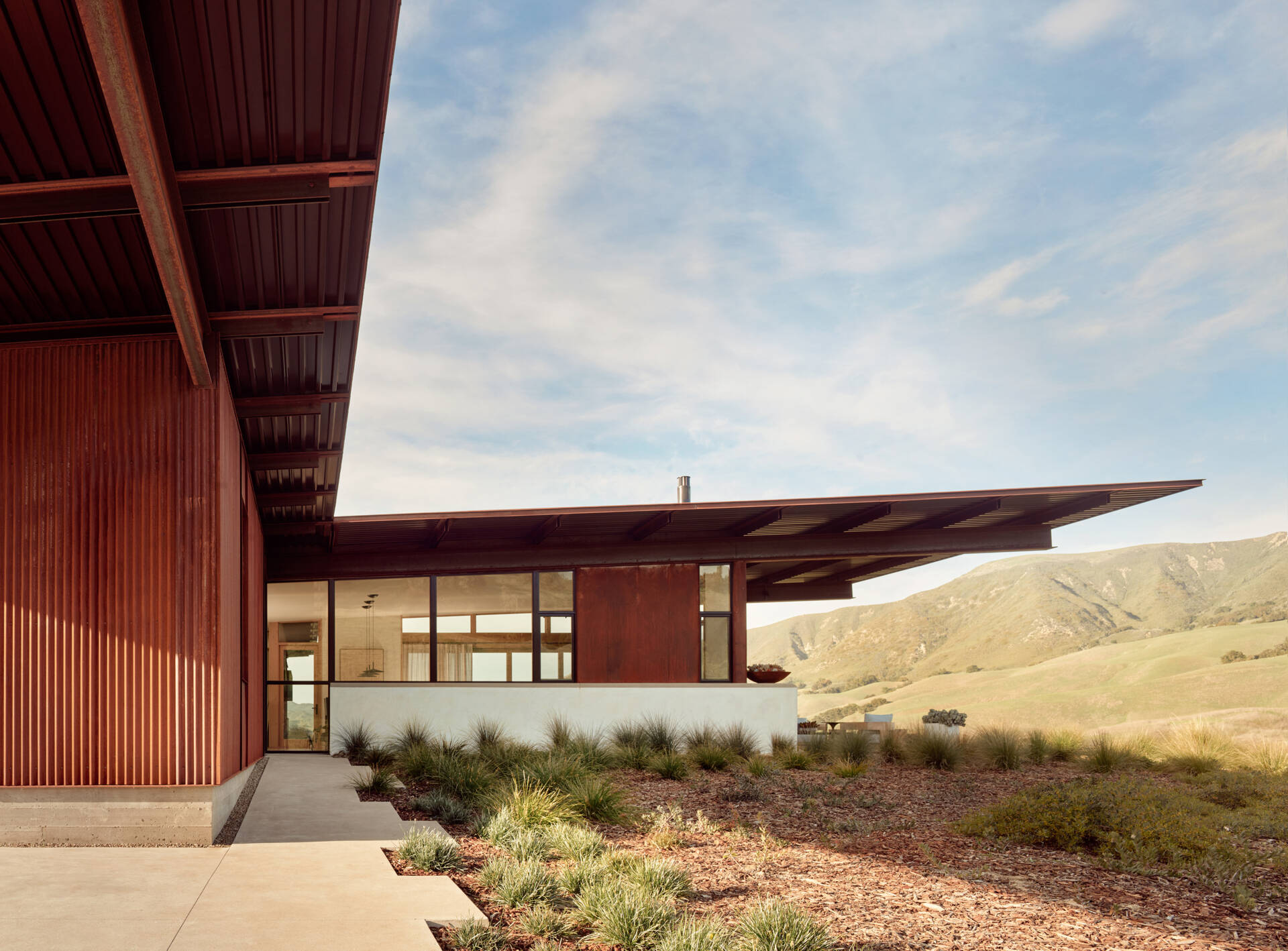 Explore the compact T-shaped plan of Vineyard Residence by Clayton Korte, with private bedroom suites surrounding a central kitchen and living area and outdoor spaces extending at both ends.