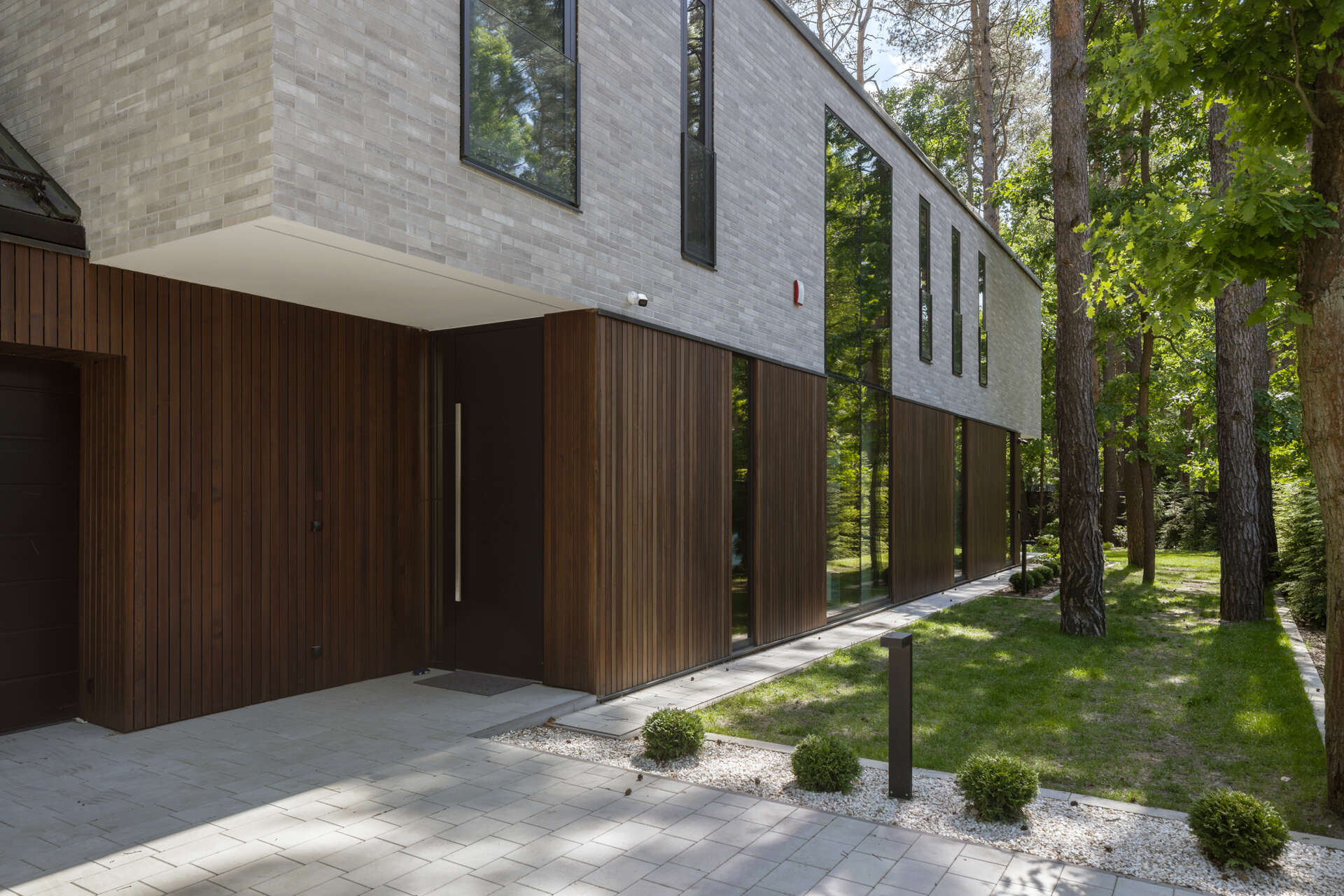 Two intersecting volumes give The Intersecting House near Warsaw its distinctive form. Designed by Exterio Architektura, the home combines pitched roofs, contrasting materials and a strong relationship with the surrounding pine forest.