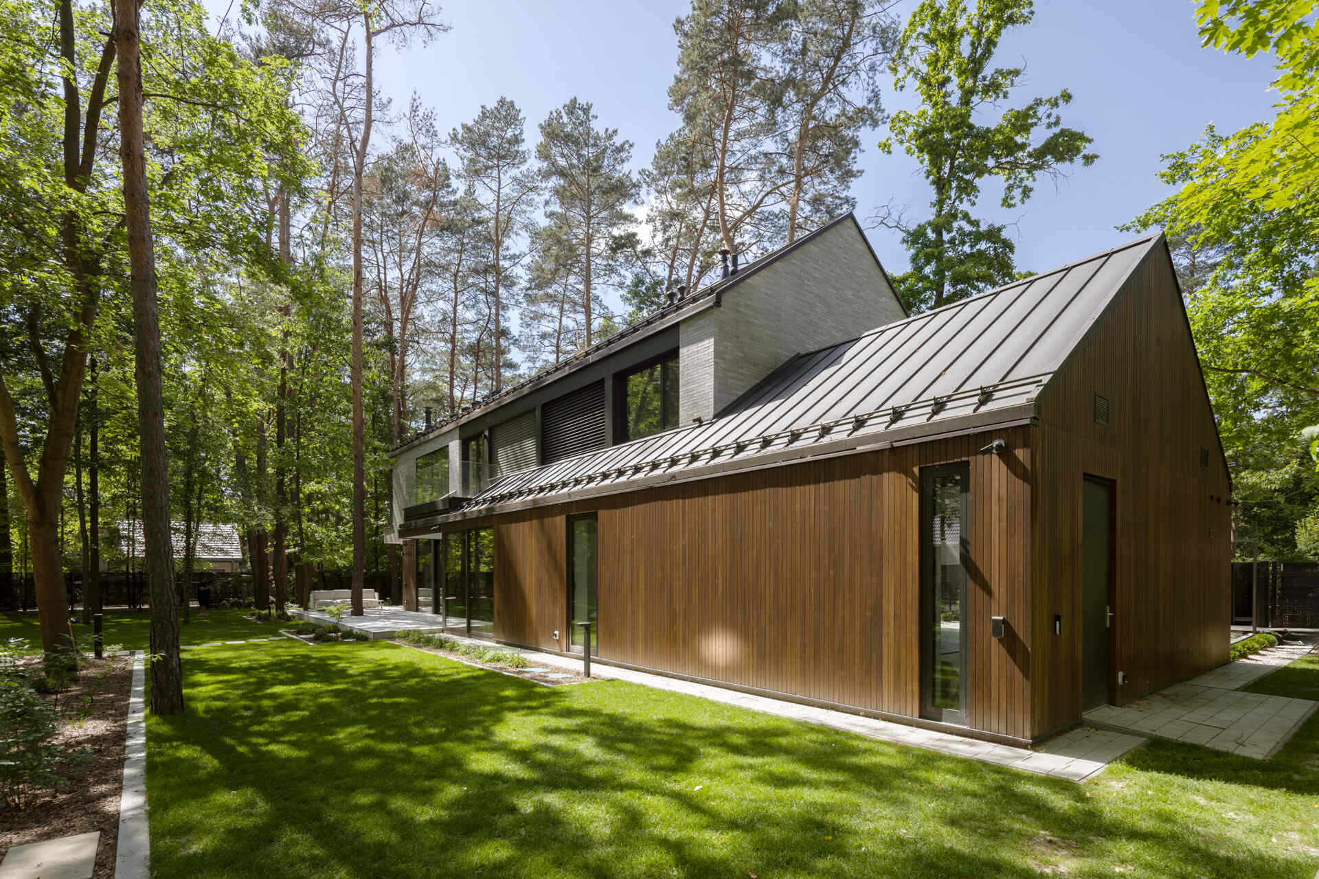 Two intersecting volumes give The Intersecting House near Warsaw its distinctive form. Designed by Exterio Architektura, the home combines pitched roofs, contrasting materials and a strong relationship with the surrounding pine forest.