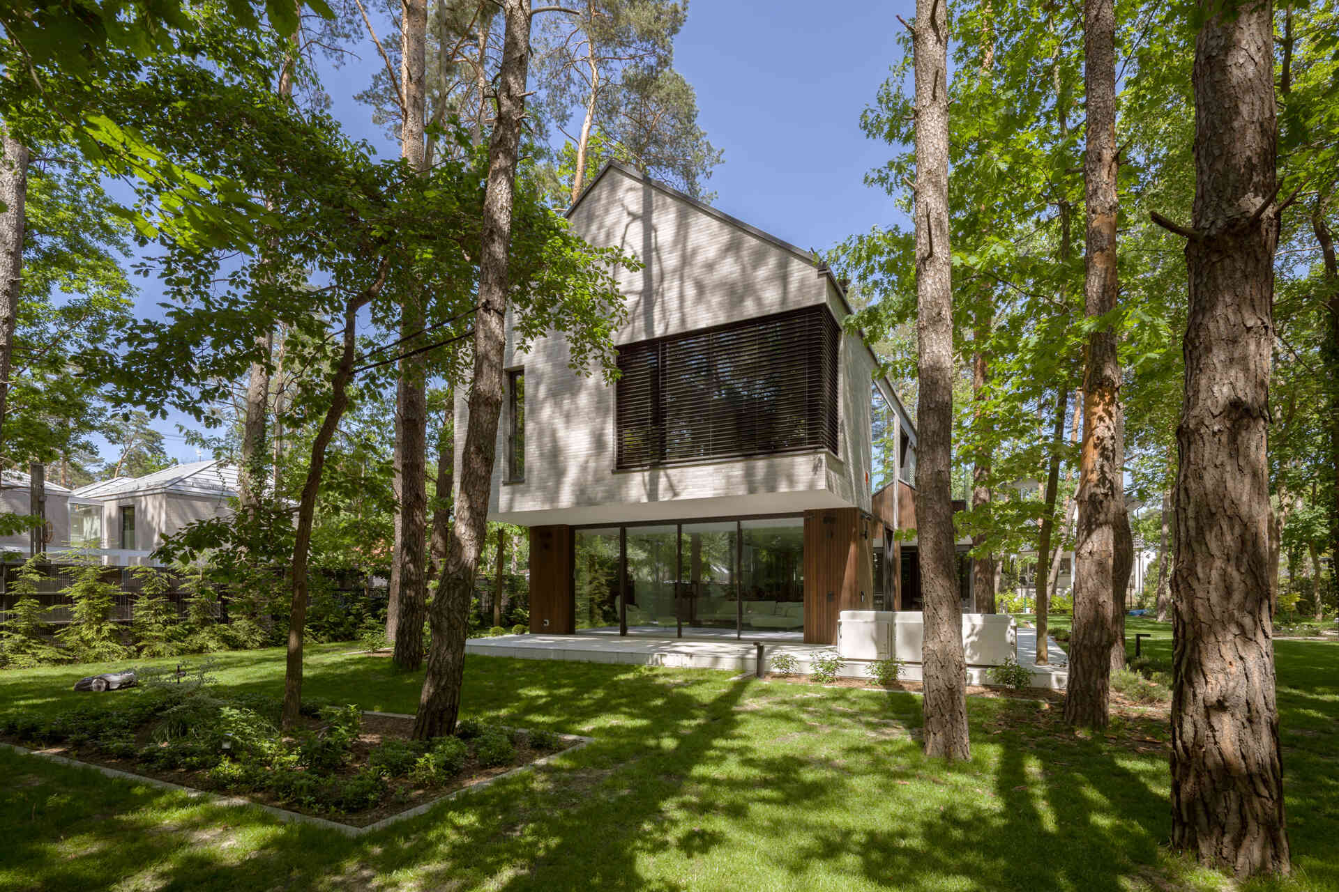 Two intersecting volumes give The Intersecting House near Warsaw its distinctive form. Designed by Exterio Architektura, the home combines pitched roofs, contrasting materials and a strong relationship with the surrounding pine forest.