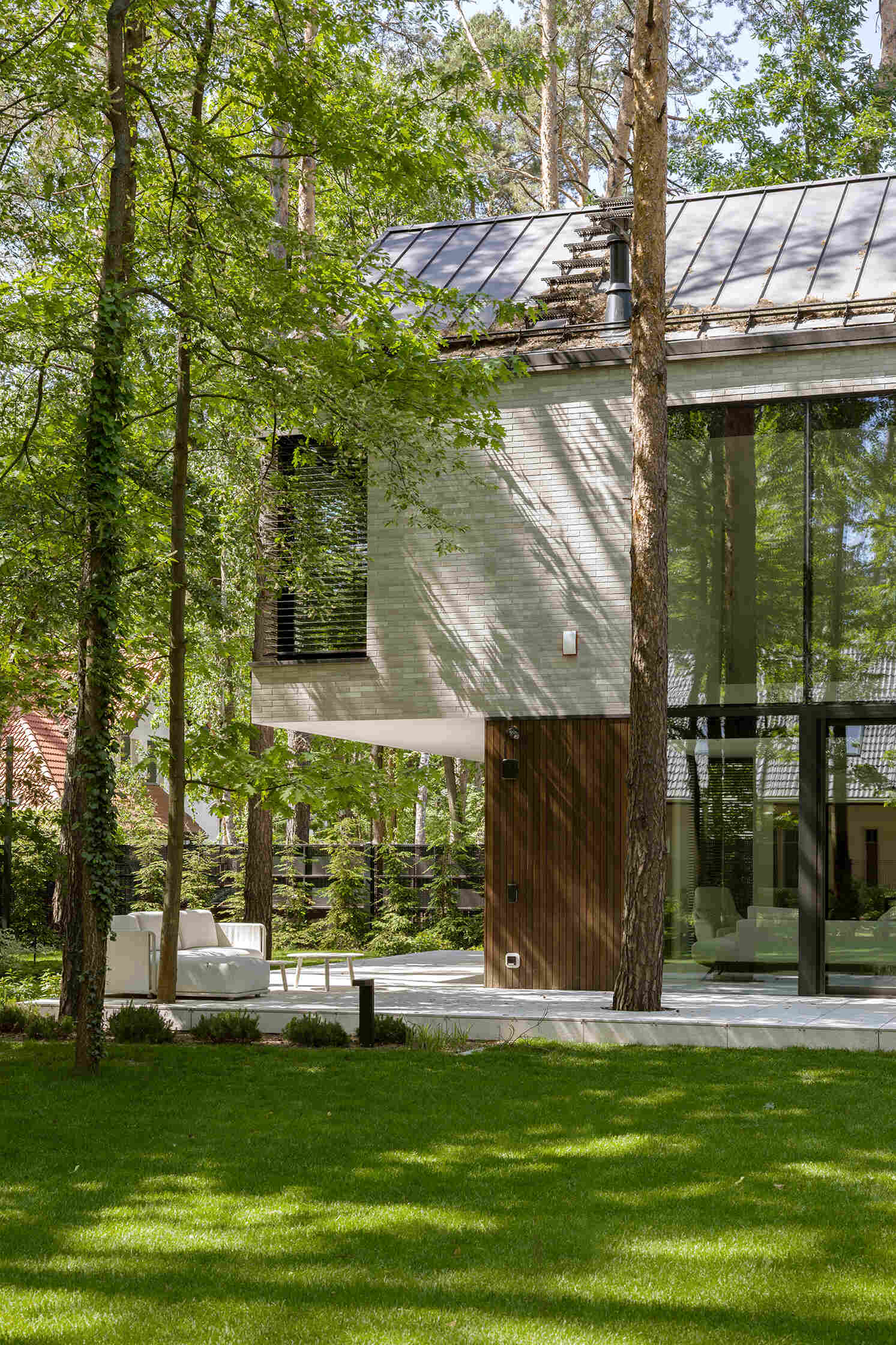 Two intersecting volumes give The Intersecting House near Warsaw its distinctive form. Designed by Exterio Architektura, the home combines pitched roofs, contrasting materials and a strong relationship with the surrounding pine forest.