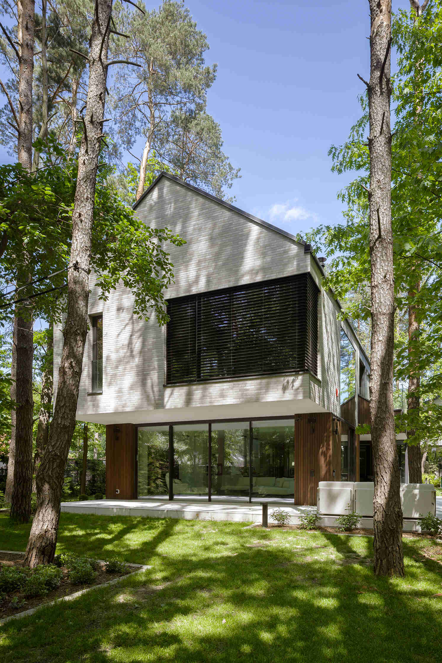 Two intersecting volumes give The Intersecting House near Warsaw its distinctive form. Designed by Exterio Architektura, the home combines pitched roofs, contrasting materials and a strong relationship with the surrounding pine forest.