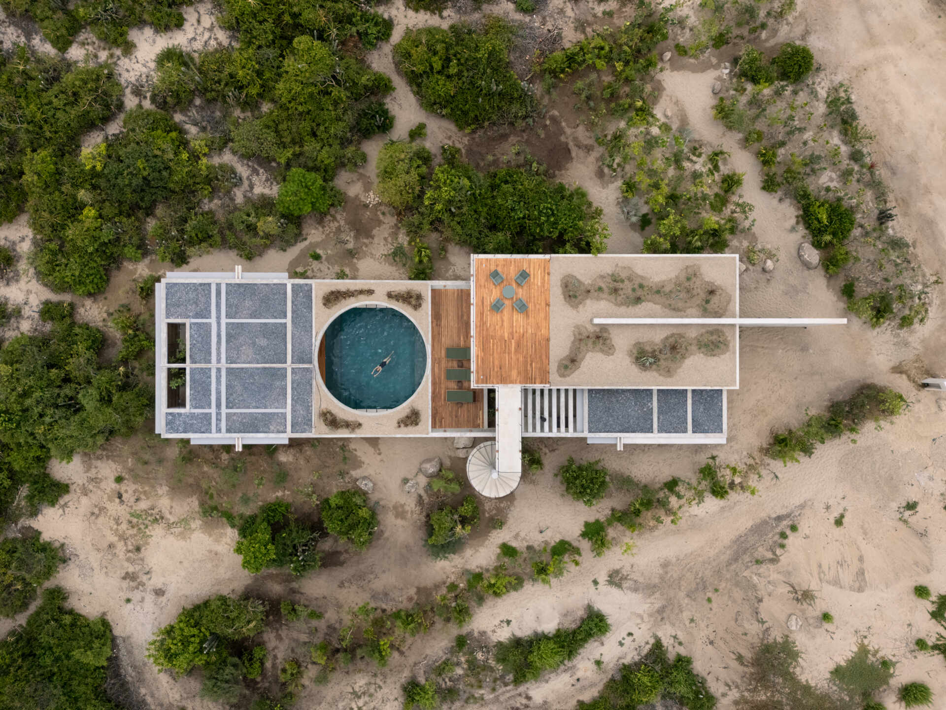 The Casa Cieno floor plan places the central pool between the social and private areas, with the two bedrooms reached by paths crossing over the water.
