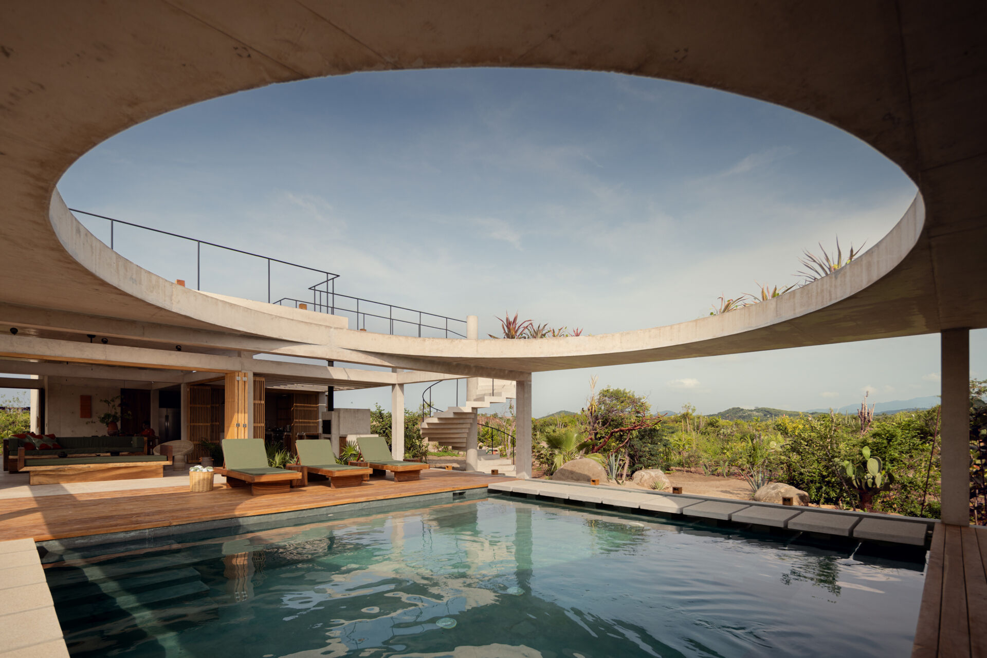 A central pool forms the heart of Casa Cieno, separating the social and private spaces while creating floating pathways between the rooms.