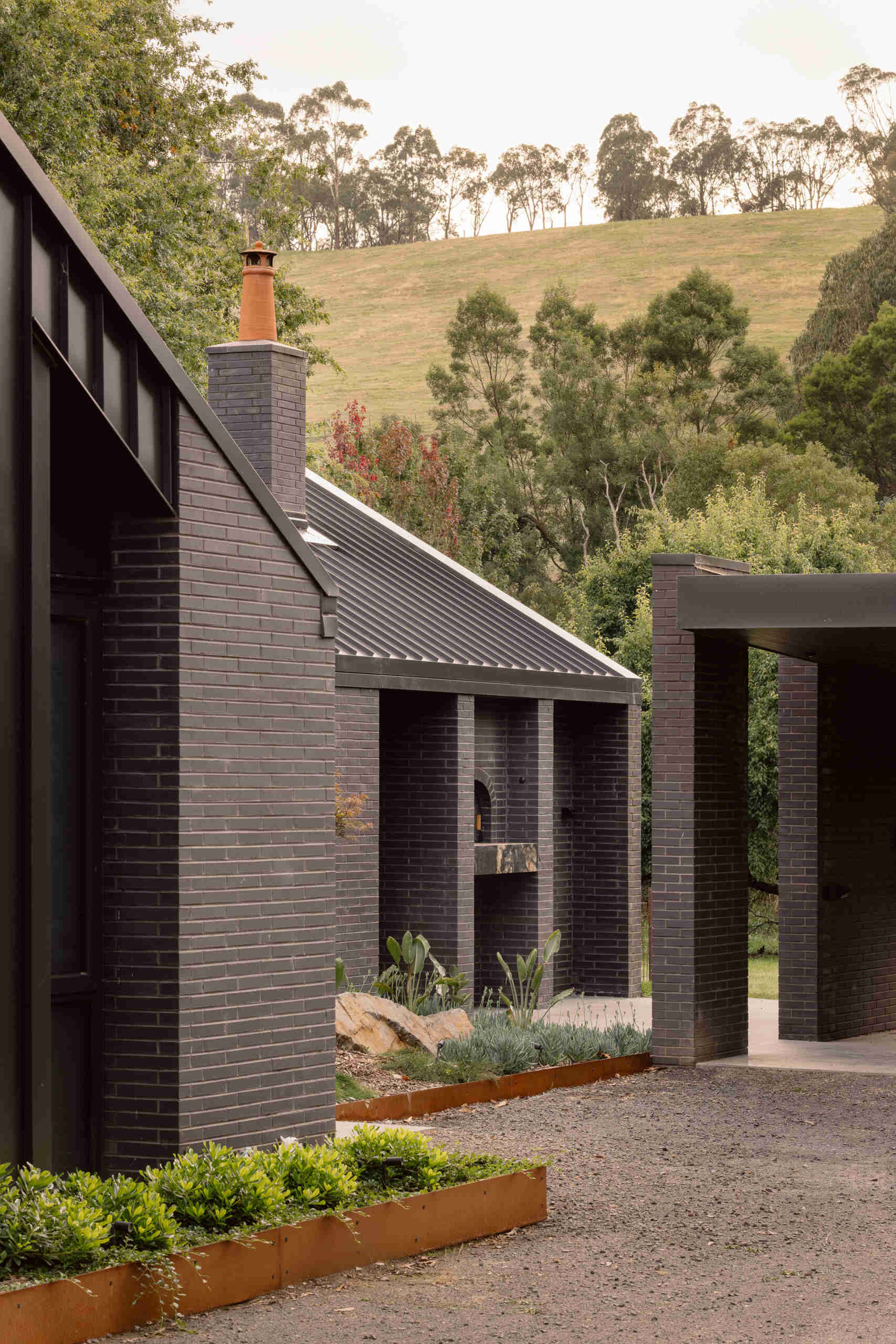 Explore the dark masonry and metal palette of Yarra Valley House, where durable exterior materials meet the practical demands of bushfire-resistant Australian architecture.
