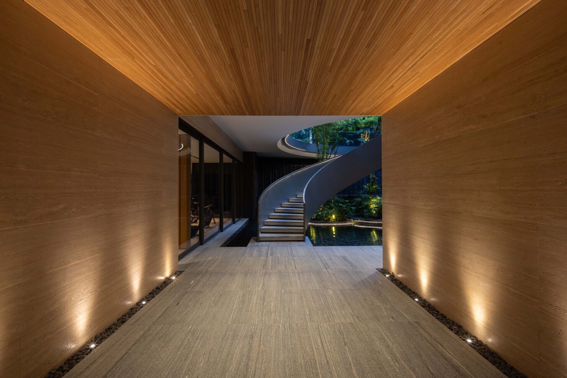 Two tall atriums bring trees, water, daylight and open sky into the heart of this Singapore family home.