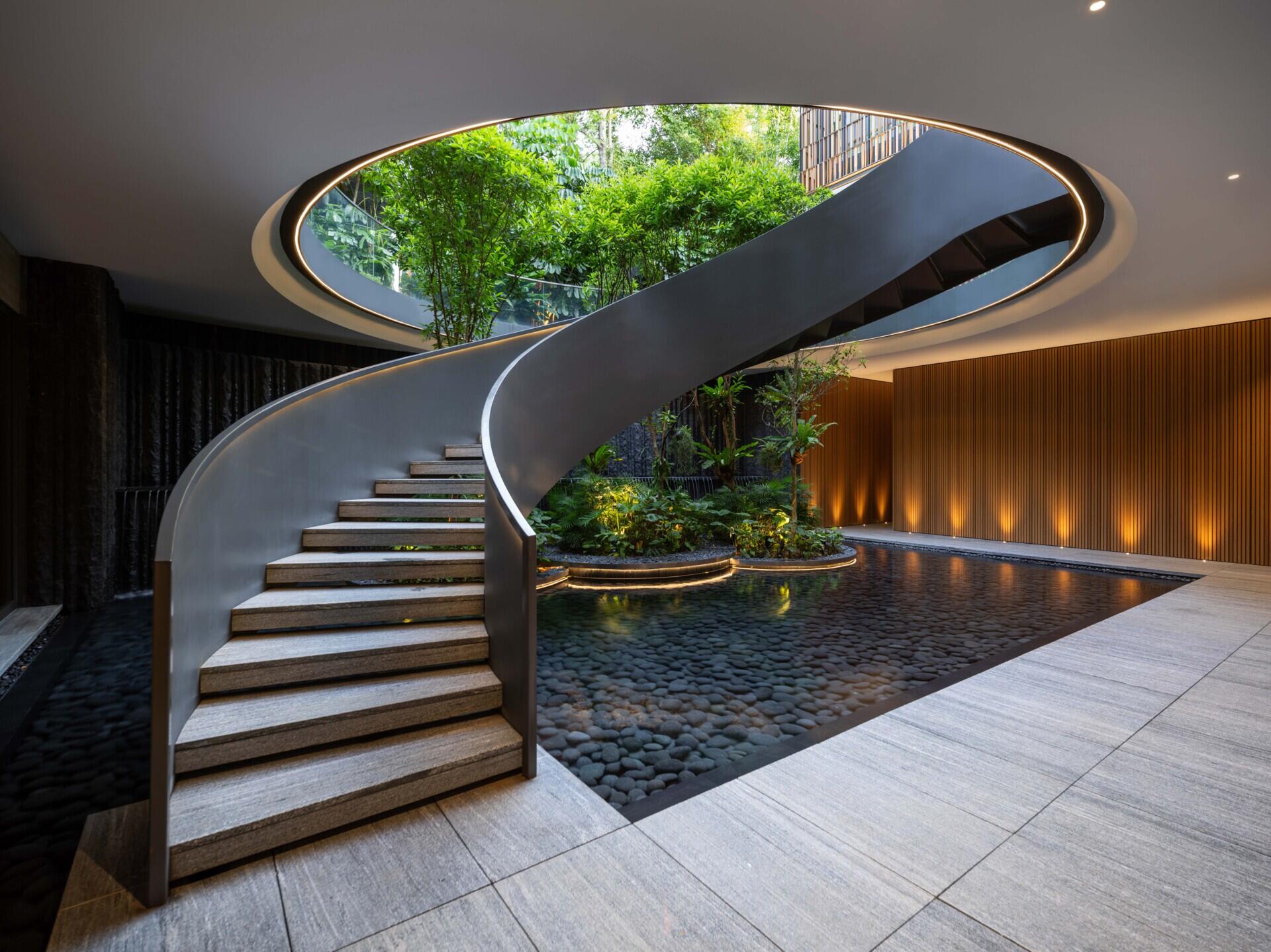 Two tall atriums bring trees, water, daylight and open sky into the heart of this Singapore family home.