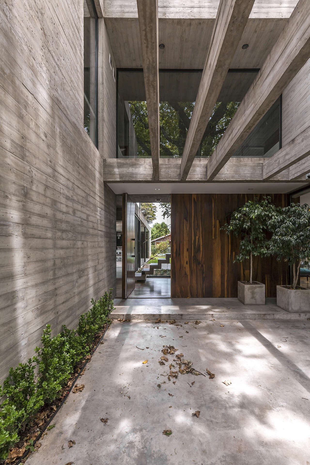 A large pivoting wood front door creates a beautiful entrance to Casa Aranzazu, with a view extending through the house toward the backyard.