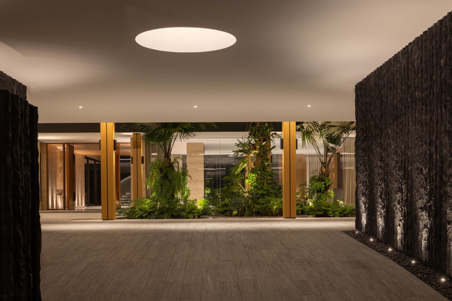 Two tall atriums bring trees, water, daylight and open sky into the heart of this Singapore family home.