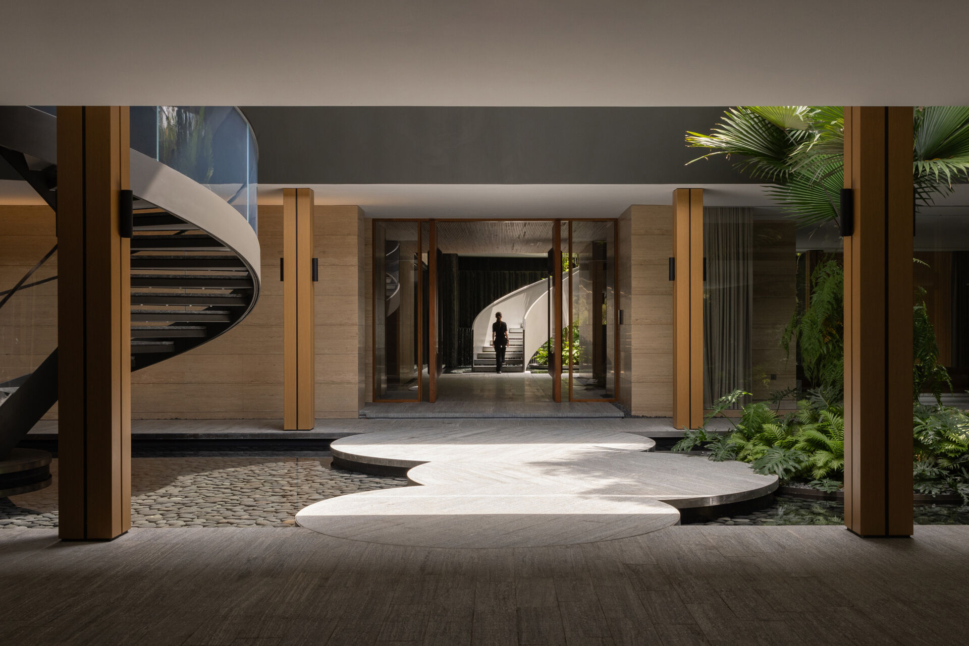 Two tall atriums bring trees, water, daylight and open sky into the heart of this Singapore family home.