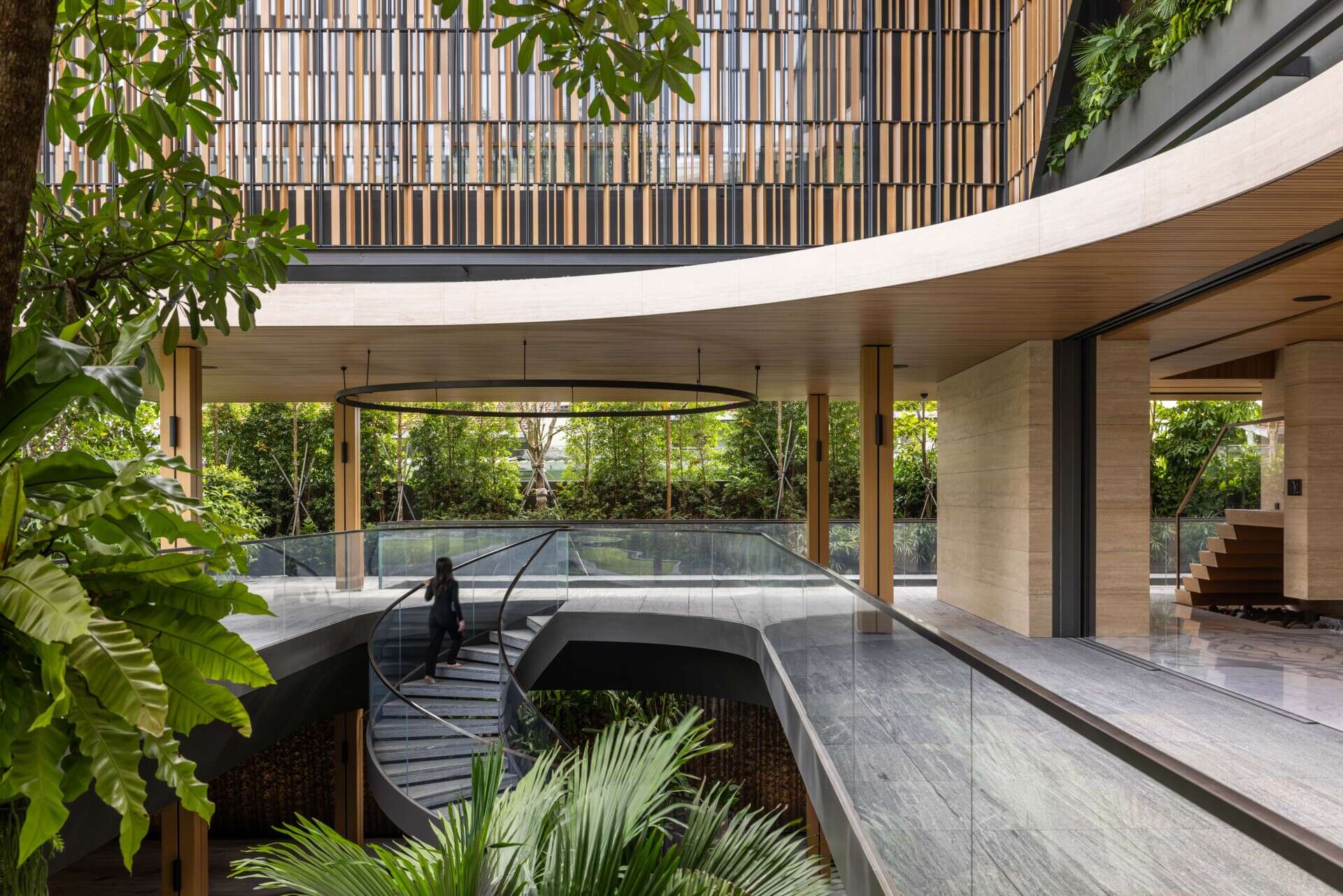 Two tall atriums bring trees, water, daylight and open sky into the heart of this Singapore family home.