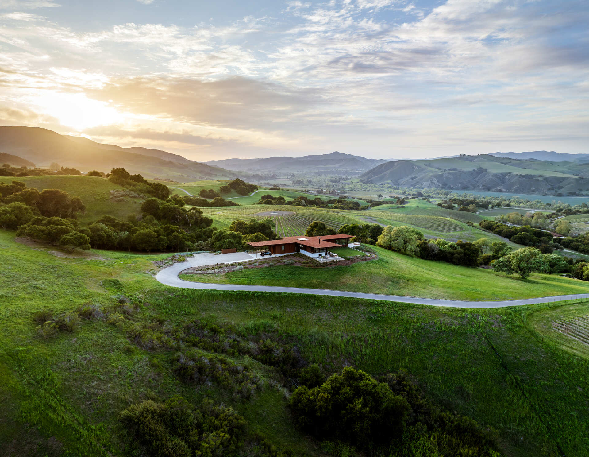 Explore the compact T-shaped plan of Vineyard Residence by Clayton Korte, with private bedroom suites surrounding a central kitchen and living area and outdoor spaces extending at both ends.