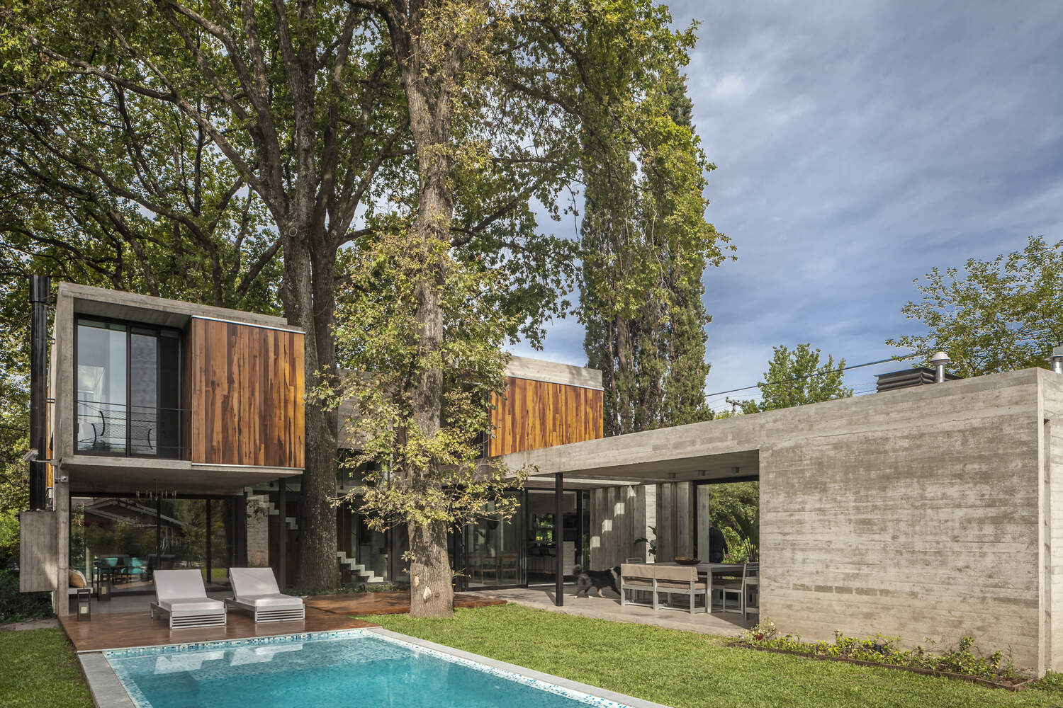 Casa Aranzazu opens toward a backyard with a covered outdoor dining area, bar and swimming pool, creating an easy connection between the interior and garden.