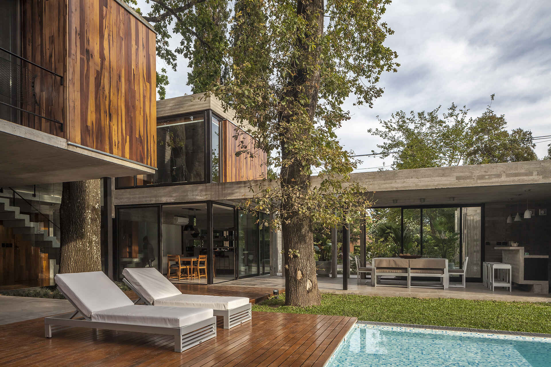 Casa Aranzazu opens toward a backyard with a covered outdoor dining area, bar and swimming pool, creating an easy connection between the interior and garden.