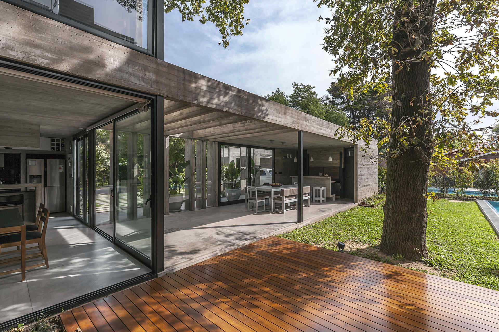 Casa Aranzazu opens toward a backyard with a covered outdoor dining area, bar and swimming pool, creating an easy connection between the interior and garden.