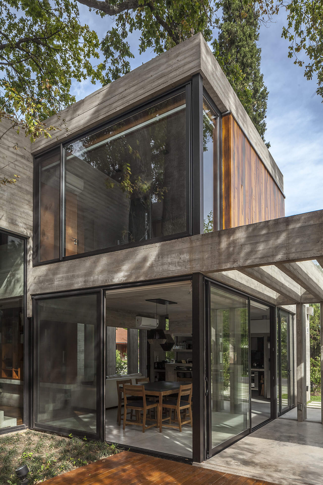 Casa Aranzazu opens toward a backyard with a covered outdoor dining area, bar and swimming pool, creating an easy connection between the interior and garden.
