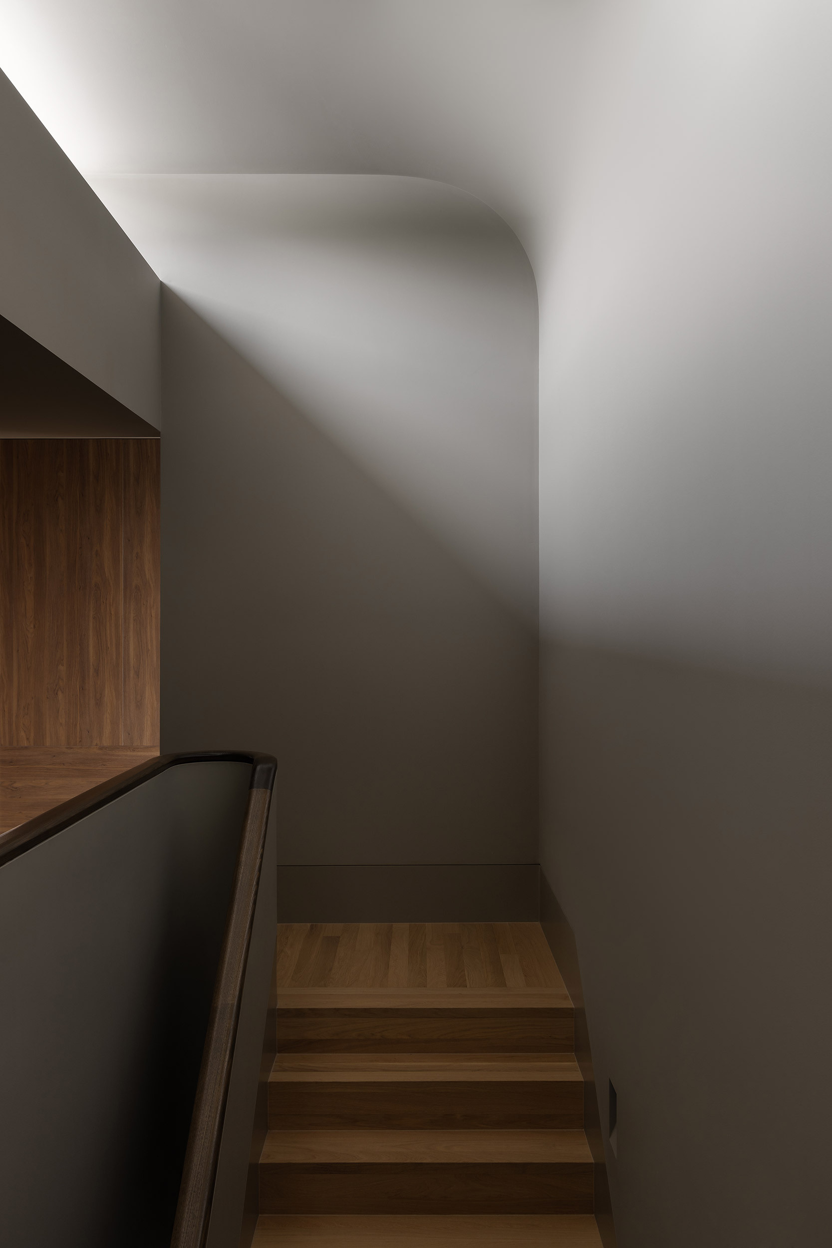 A softly detailed staircase beneath a skylight connects Casa Piva’s ground floor with the private rooms above, while drawing natural light into the darker entry area below.