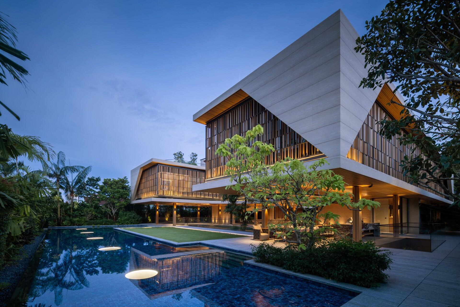 A modern house open to the outdoors with a covered outdoor living room and swimming pool.