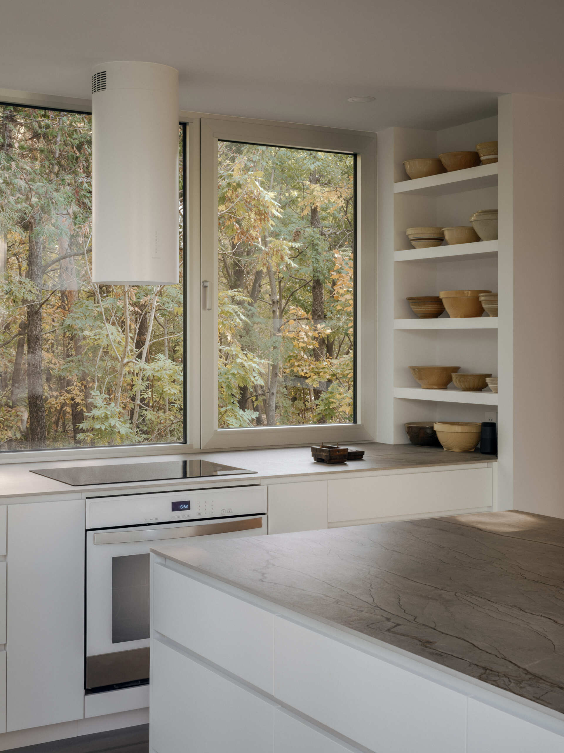 See how the dining room and kitchen are arranged around open views of the lake and forest in this contemporary Laurentians chalet by Appareil Architecture.