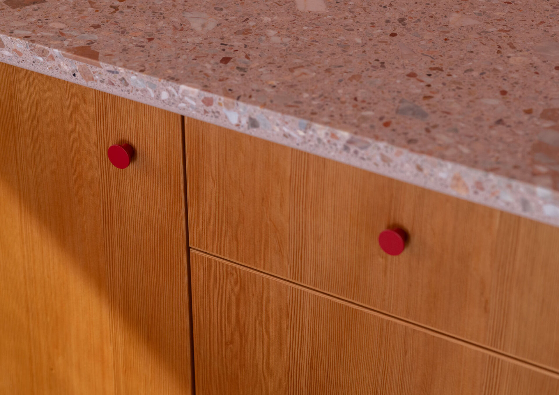 Tour the remodeled kitchen and dining area, where SHED flipped the original layout so a built-in banquette now faces Puget Sound, paired with warm timber cabinetry, pink Concrete Collaborative counters and a Zia Tile backsplash.