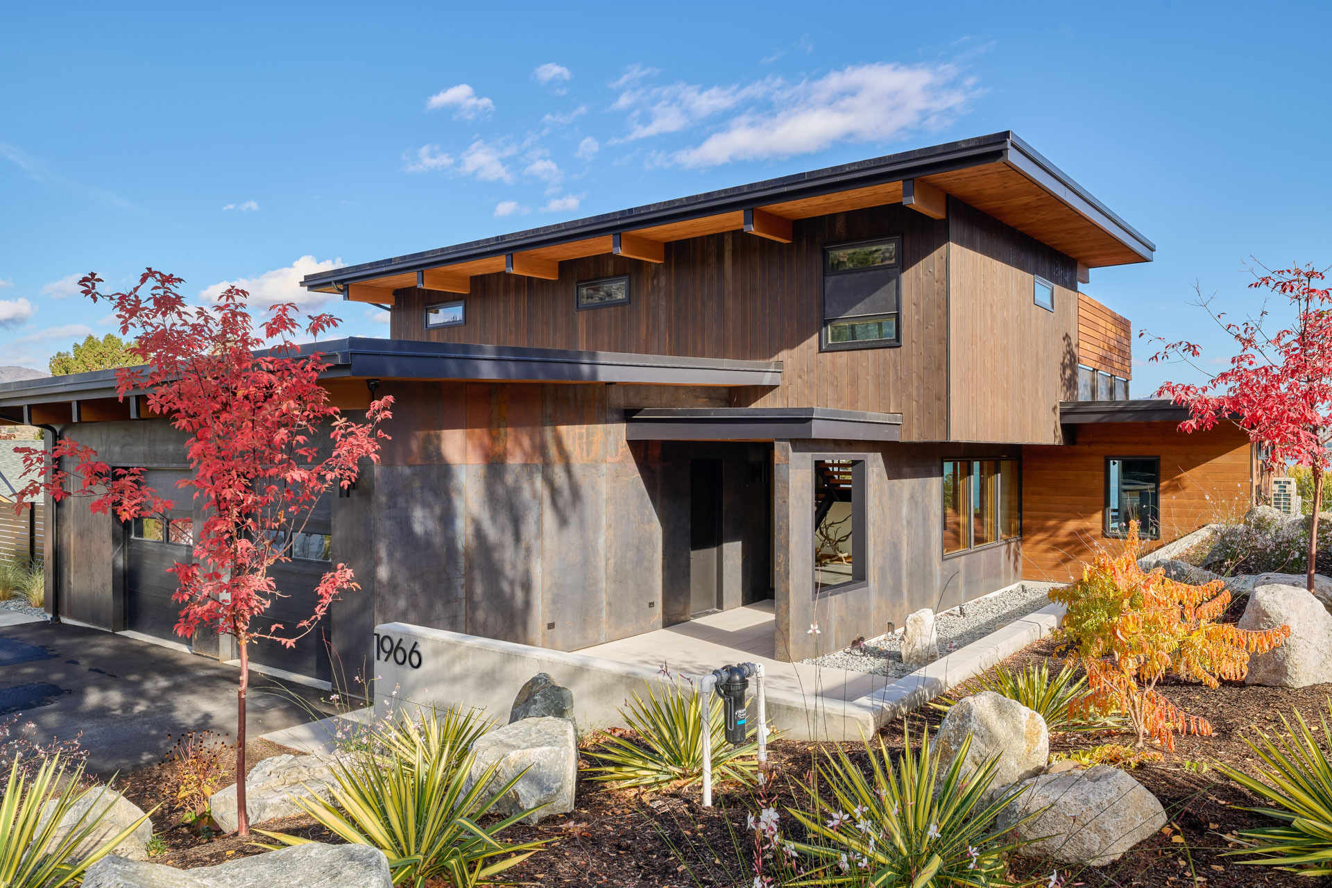 An L-shaped modern residence frames the surrounding landscape, creating a protected courtyard, pool terrace, and open views toward the lake and vineyard.