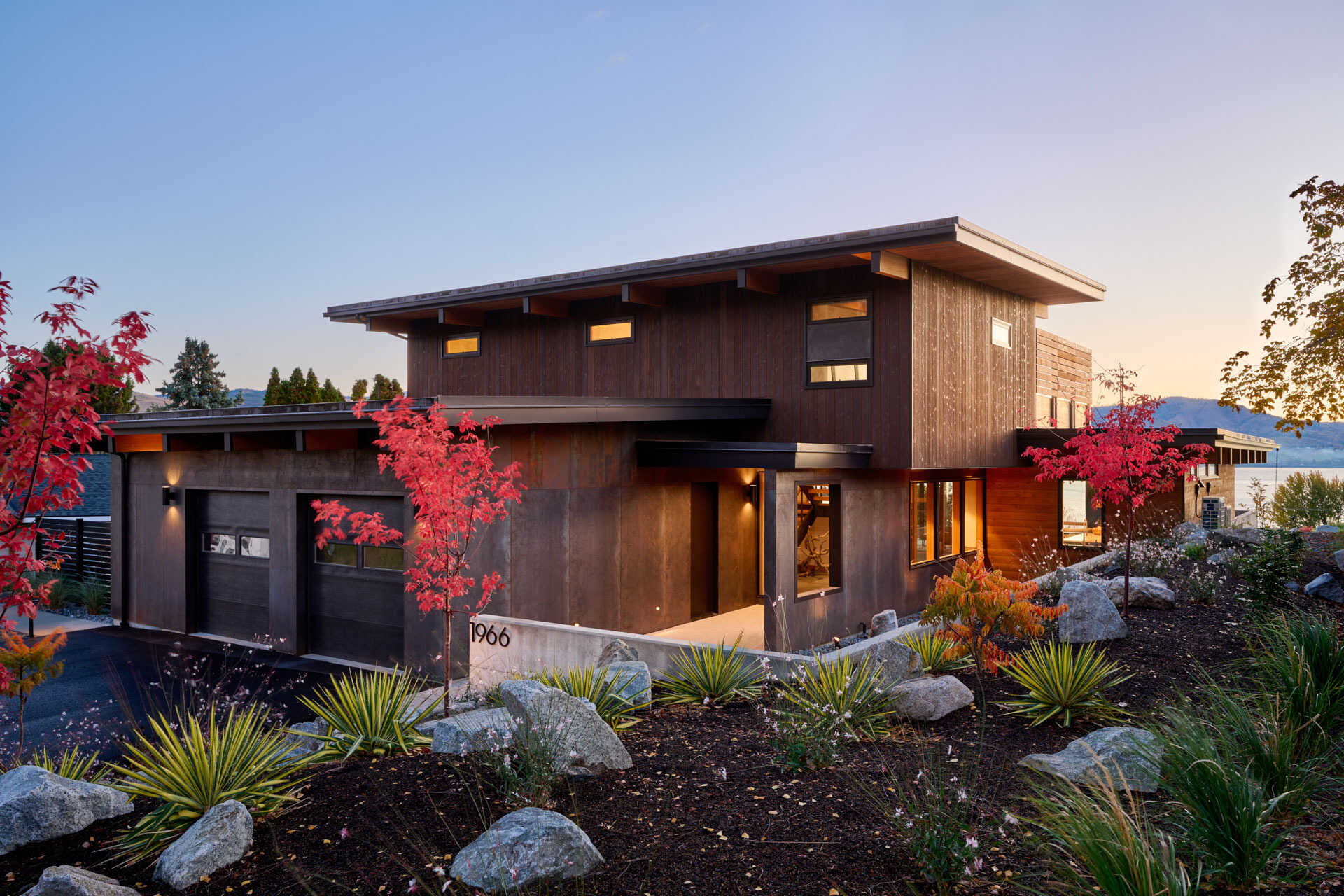 An L-shaped modern residence frames the surrounding landscape, creating a protected courtyard, pool terrace, and open views toward the lake and vineyard.