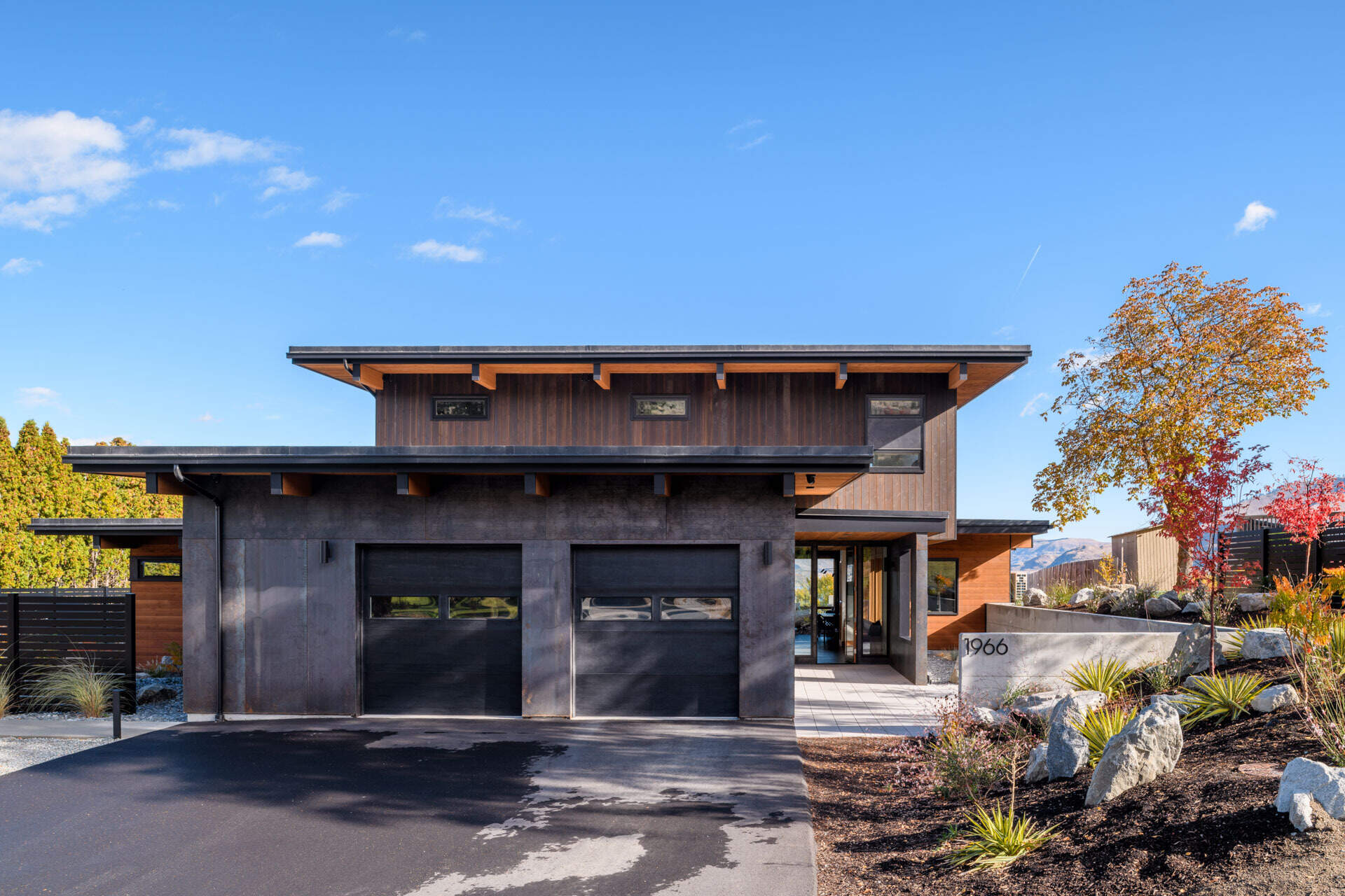 An L-shaped modern residence frames the surrounding landscape, creating a protected courtyard, pool terrace, and open views toward the lake and vineyard.