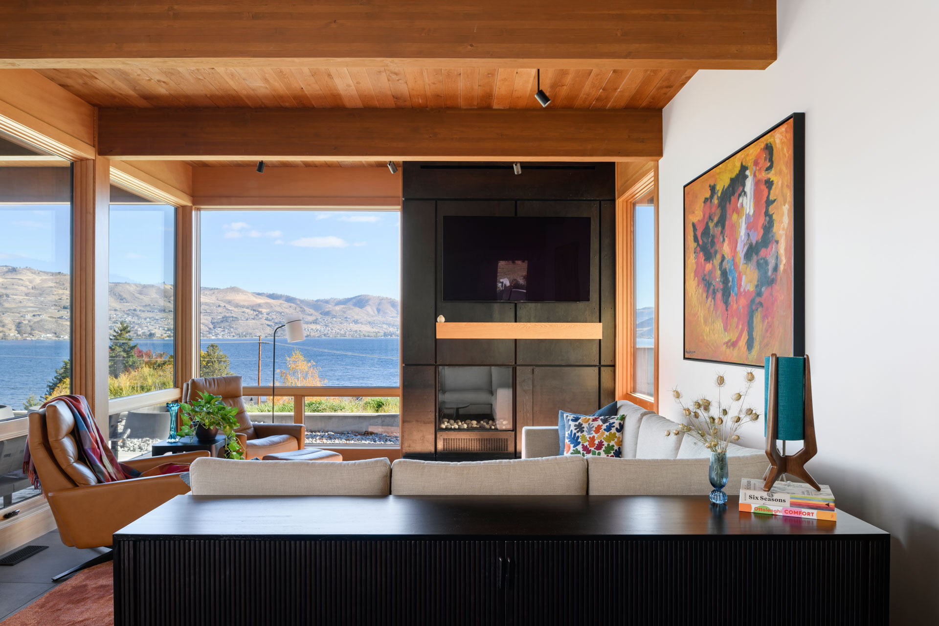 Warm timber ceilings, exposed beams, and expansive views come together in a modern living space that balances clean architecture with inviting textures.
