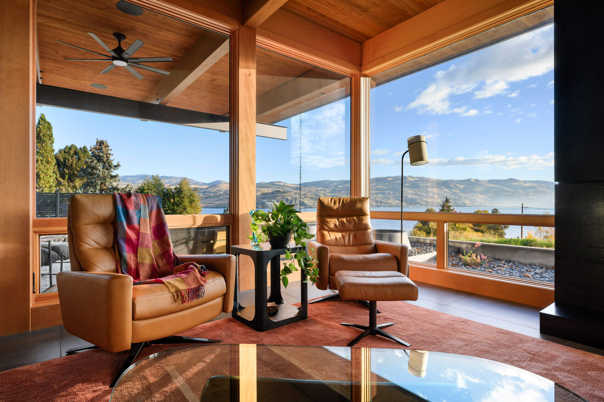 Warm timber ceilings, exposed beams, and expansive views come together in a modern living space that balances clean architecture with inviting textures.
