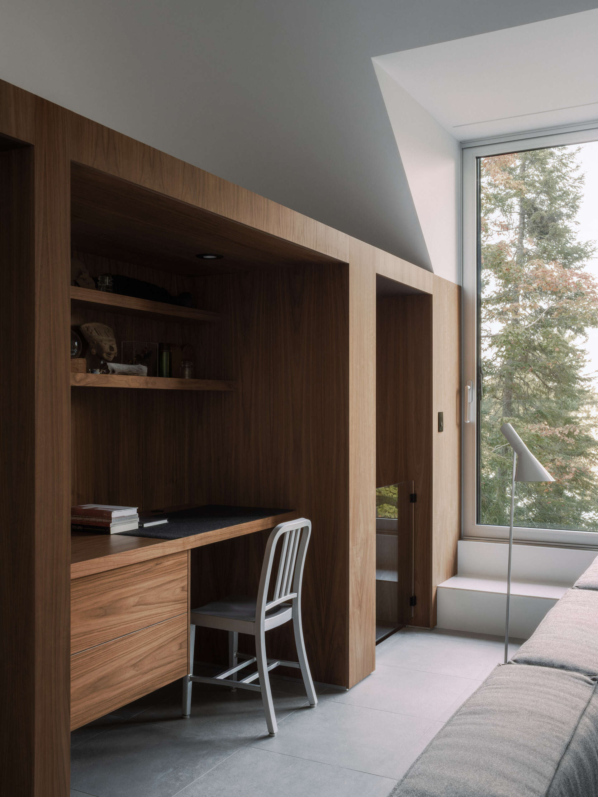 The upper-level living room at Chalet Moraine extends from the primary suite, with large dormers and deep-set glazing bringing views of the Laurentians landscape inside.