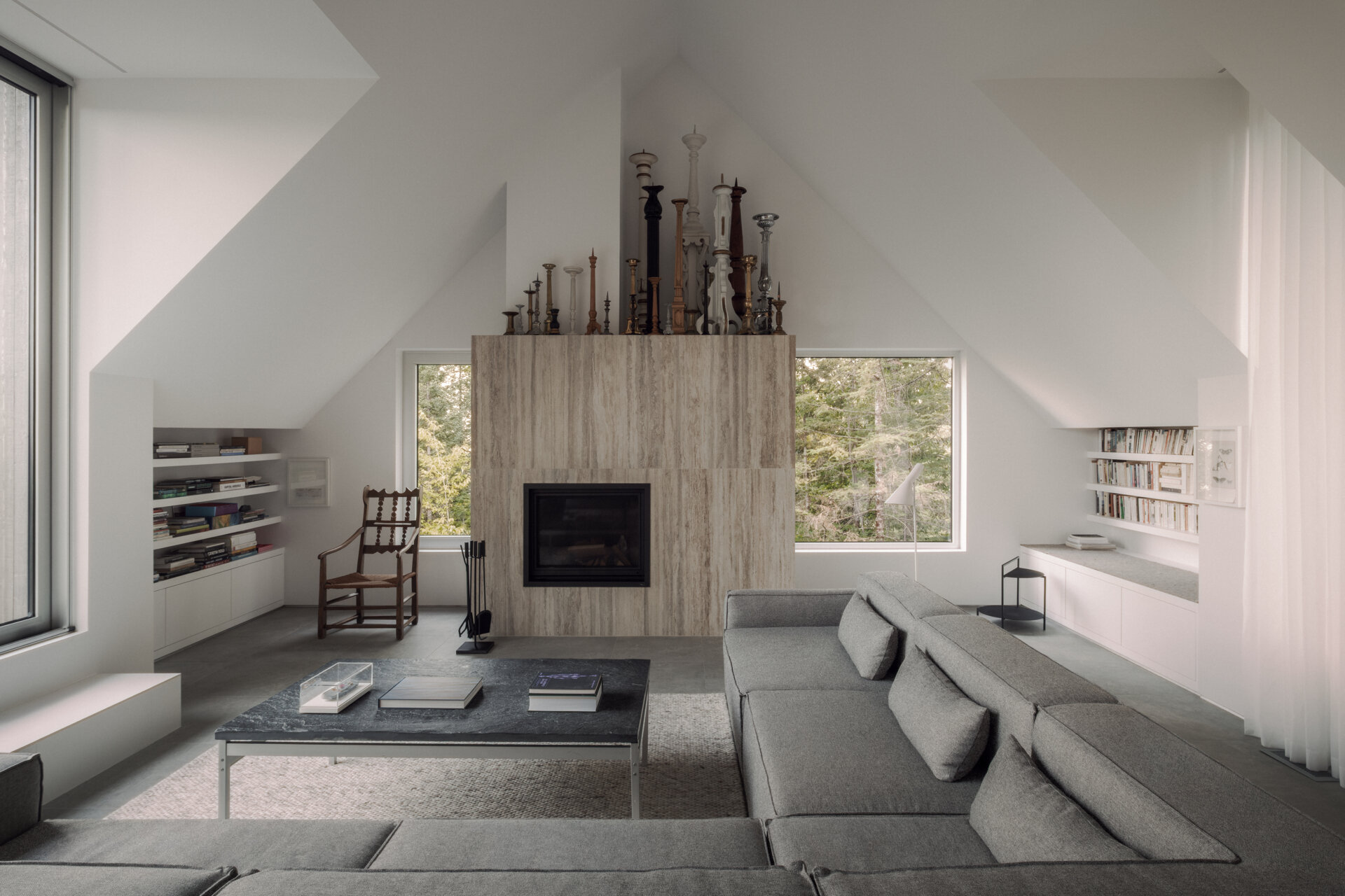The upper-level living room at Chalet Moraine extends from the primary suite, with large dormers and deep-set glazing bringing views of the Laurentians landscape inside.