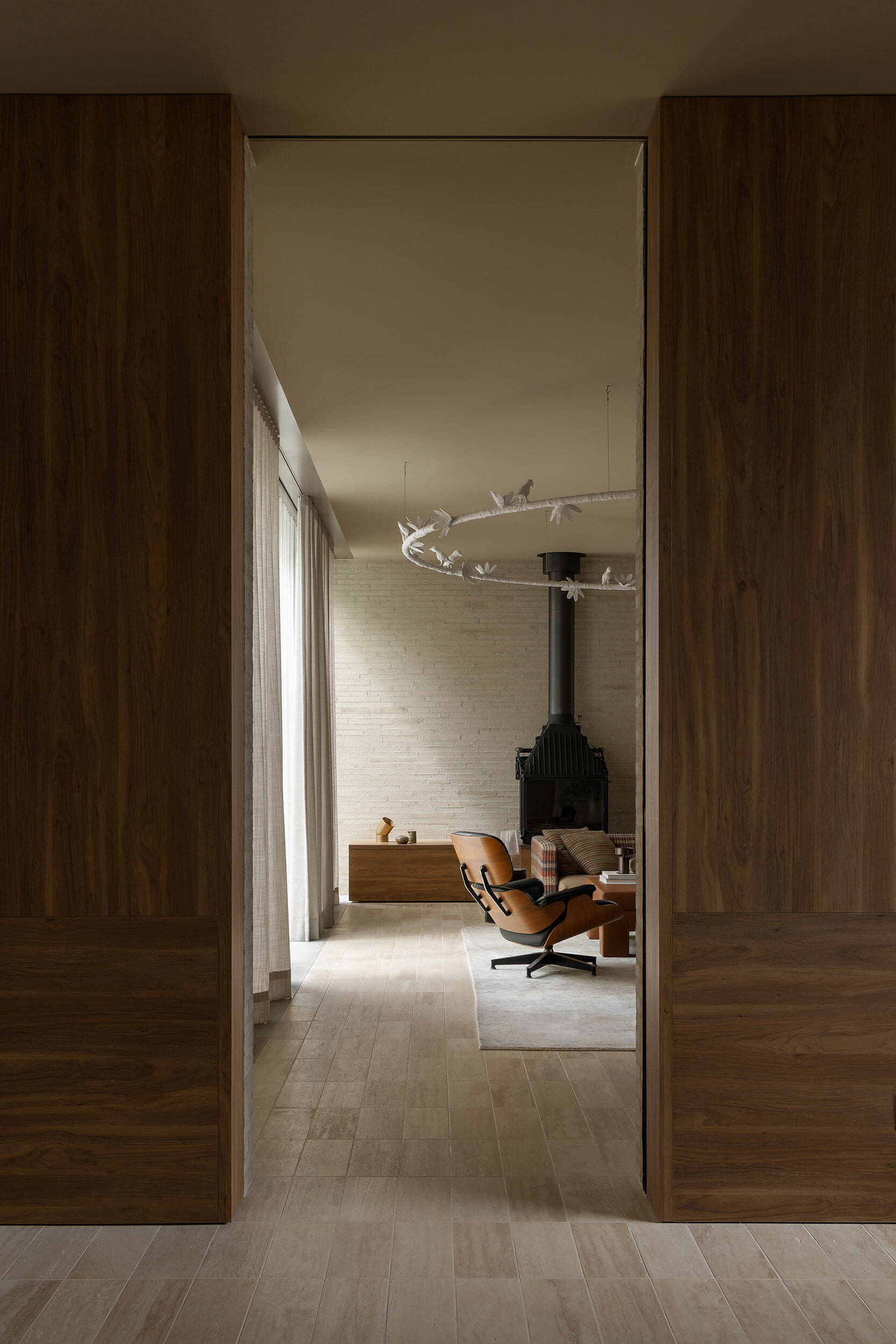 Casa Piva’s living room layers brick, timber and travertine with collected art, custom Perspex tables, an oversized plaster bird light and a sofa upholstered in vintage Missoni fabric.