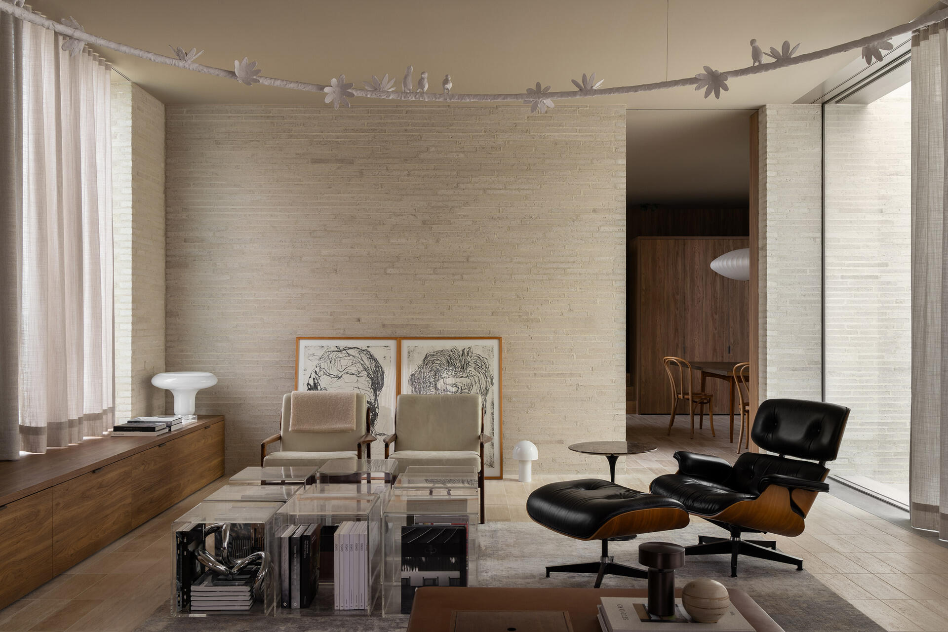 Casa Piva’s living room layers brick, timber and travertine with collected art, custom Perspex tables, an oversized plaster bird light and a sofa upholstered in vintage Missoni fabric.
