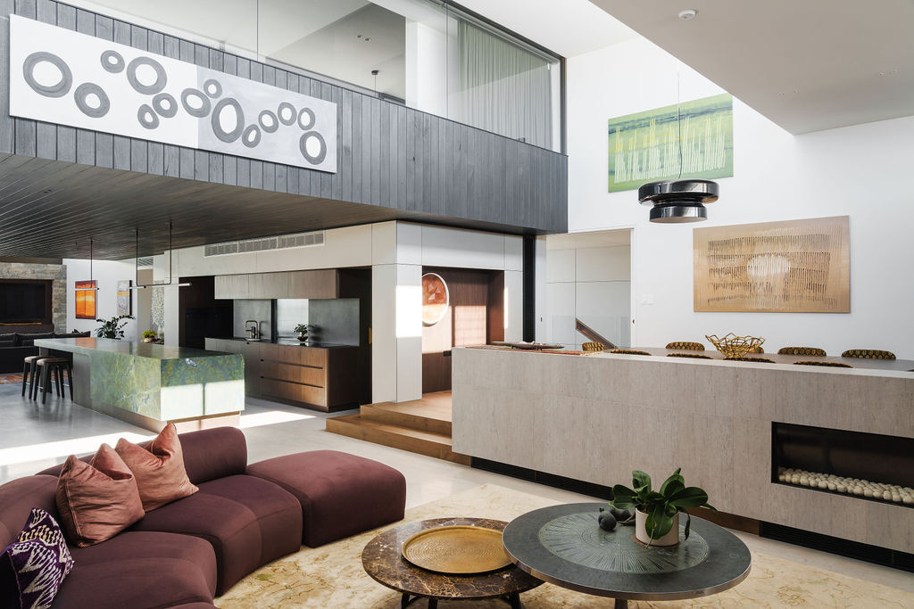 A curved couch and fireplace feature in the second living room at Mezzanine House, creating a relaxed space within the flexible Perth family home.