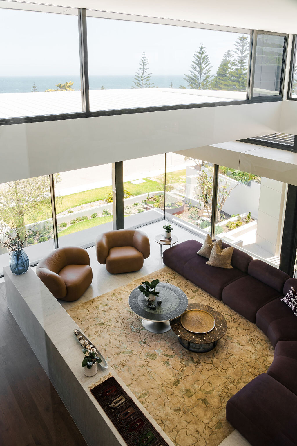 A curved couch and fireplace feature in the second living room at Mezzanine House, creating a relaxed space within the flexible Perth family home.