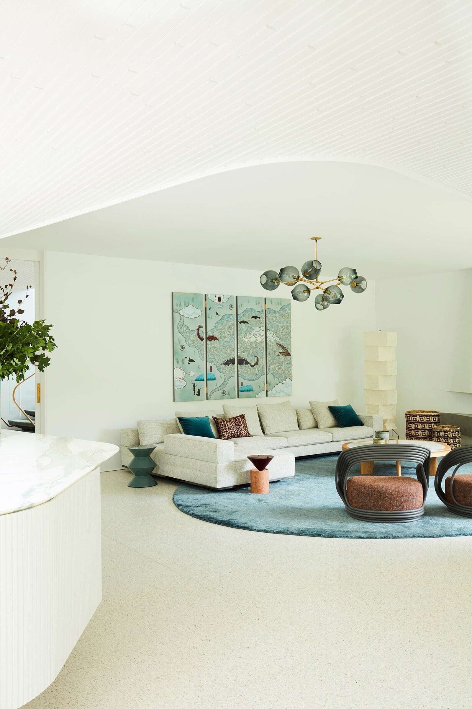Curved ceiling bulkheads, a floating concrete fireplace and restored 1960s architectural details give this Sydney modernist interior a distinctive sculptural character.