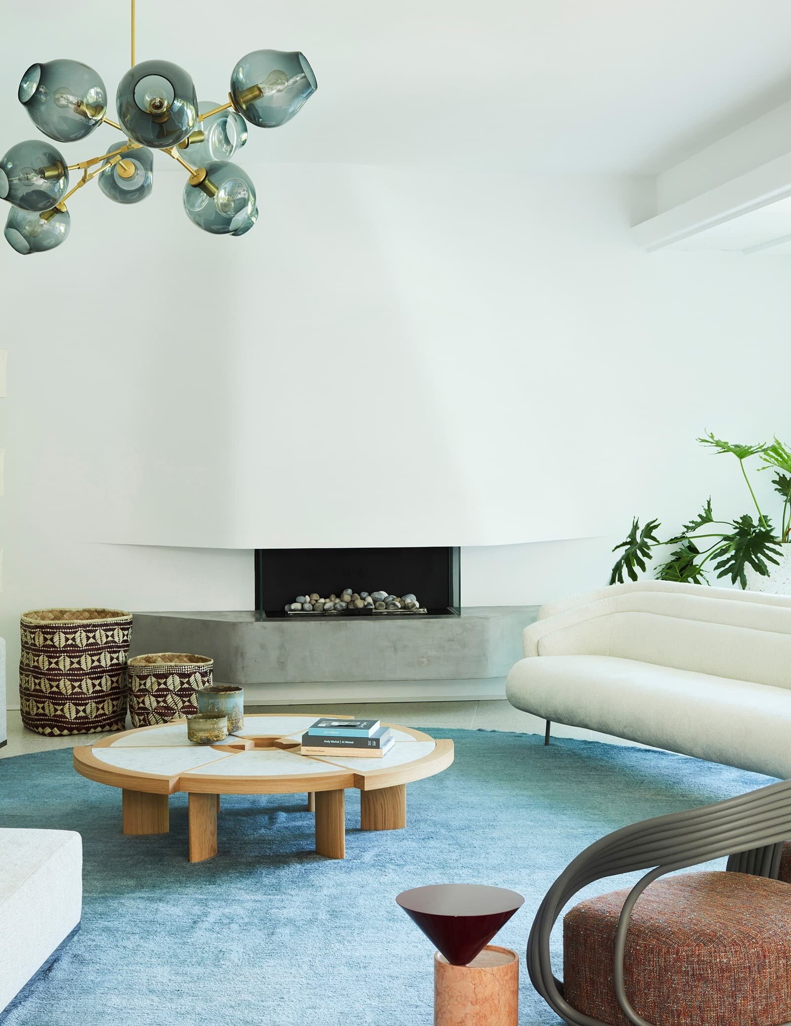 Curved ceiling bulkheads, a floating concrete fireplace and restored 1960s architectural details give this Sydney modernist interior a distinctive sculptural character.