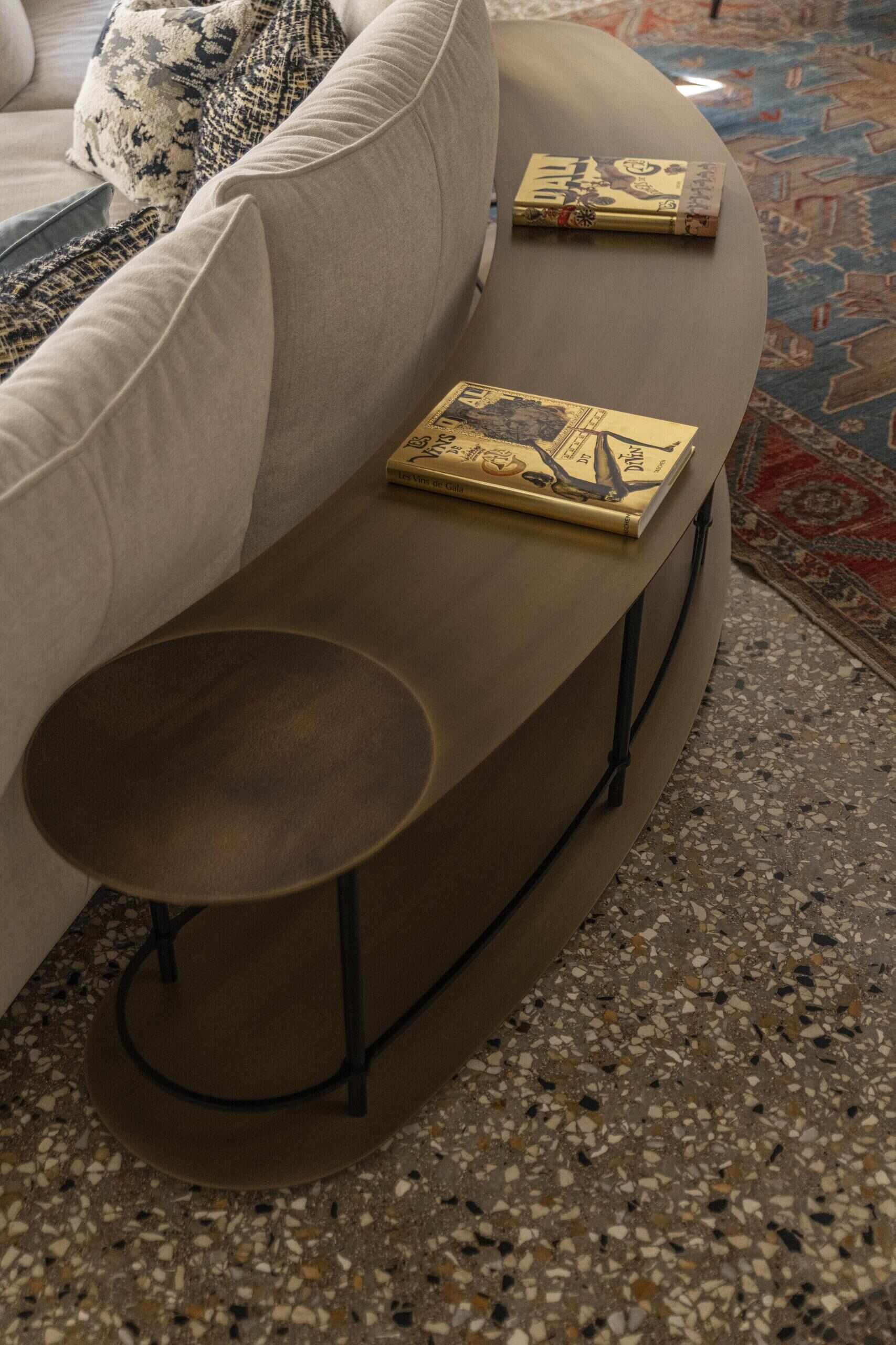 A sculptural onyx fireplace becomes the centrepiece of this Italian palazzo living room, paired with a large double-sided sofa, brass details and Venetian terrazzo.