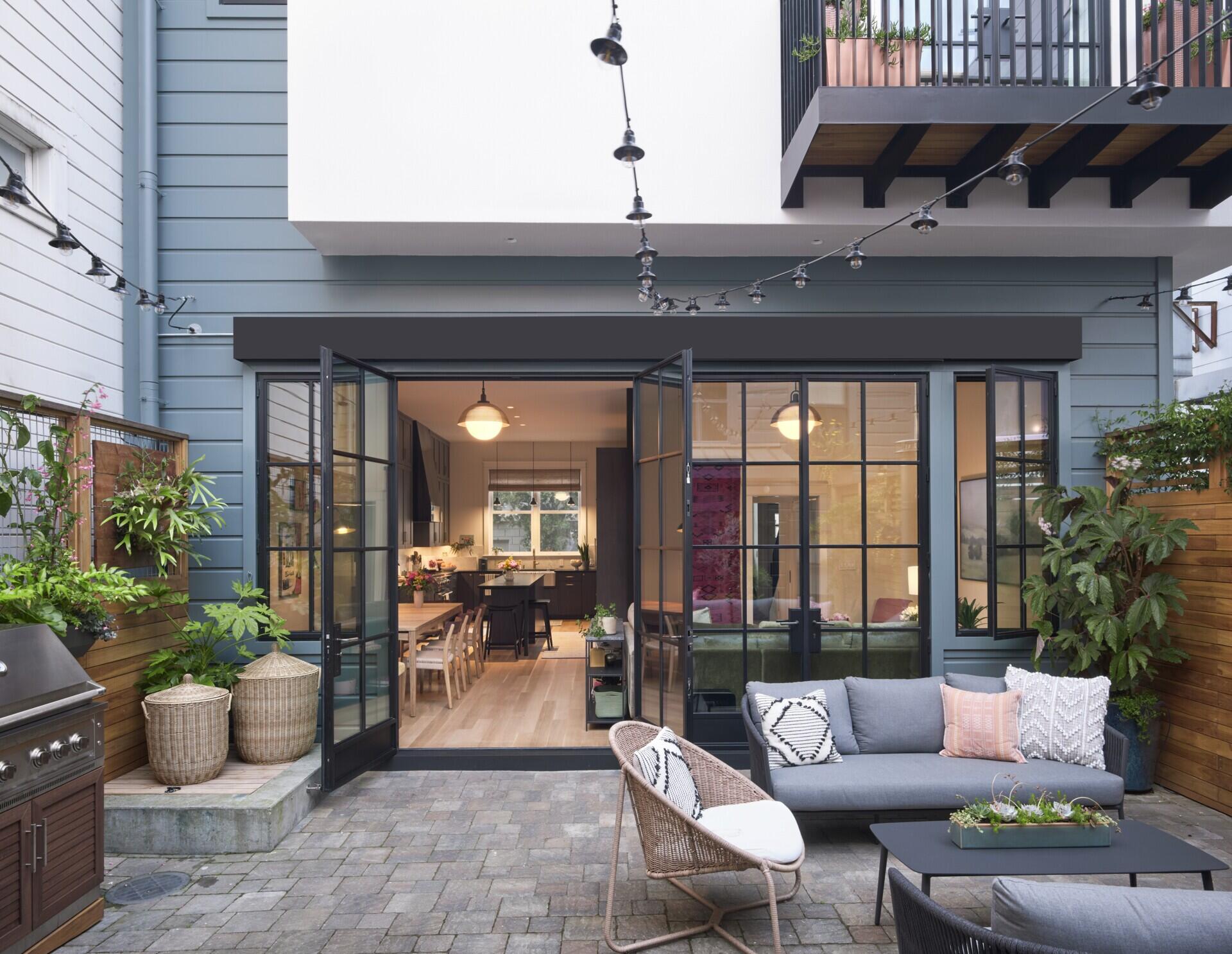 A private San Francisco courtyard links the main house and ADU, with steel-paned windows and doors opening the kitchen, dining room and primary bedroom onto the outdoor space.